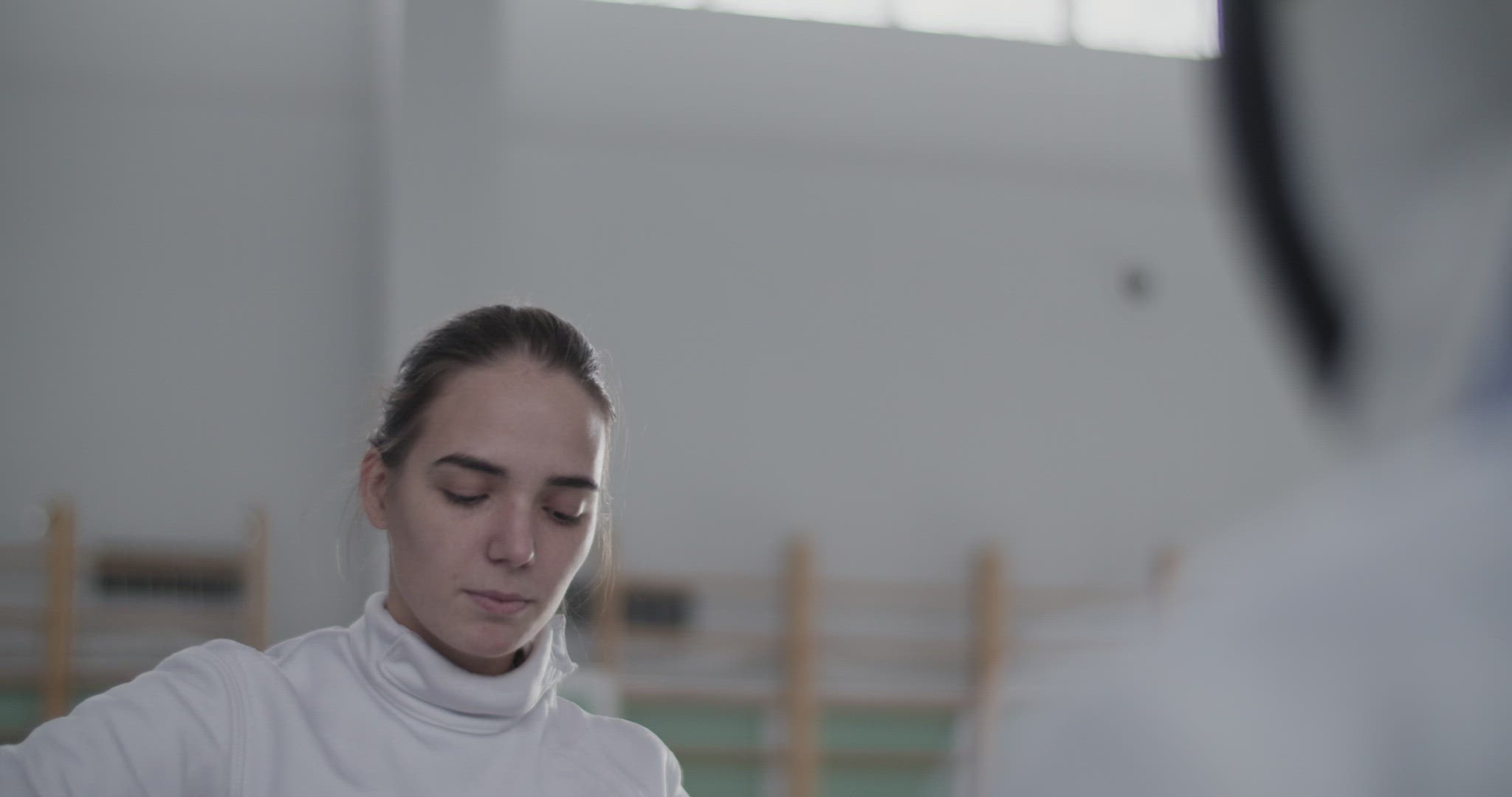 Female fencer putting on mask