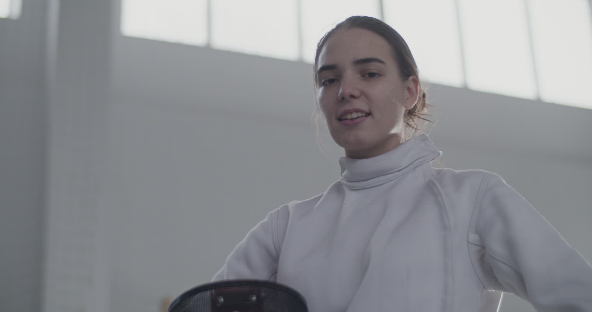 Tired young fencer in gym