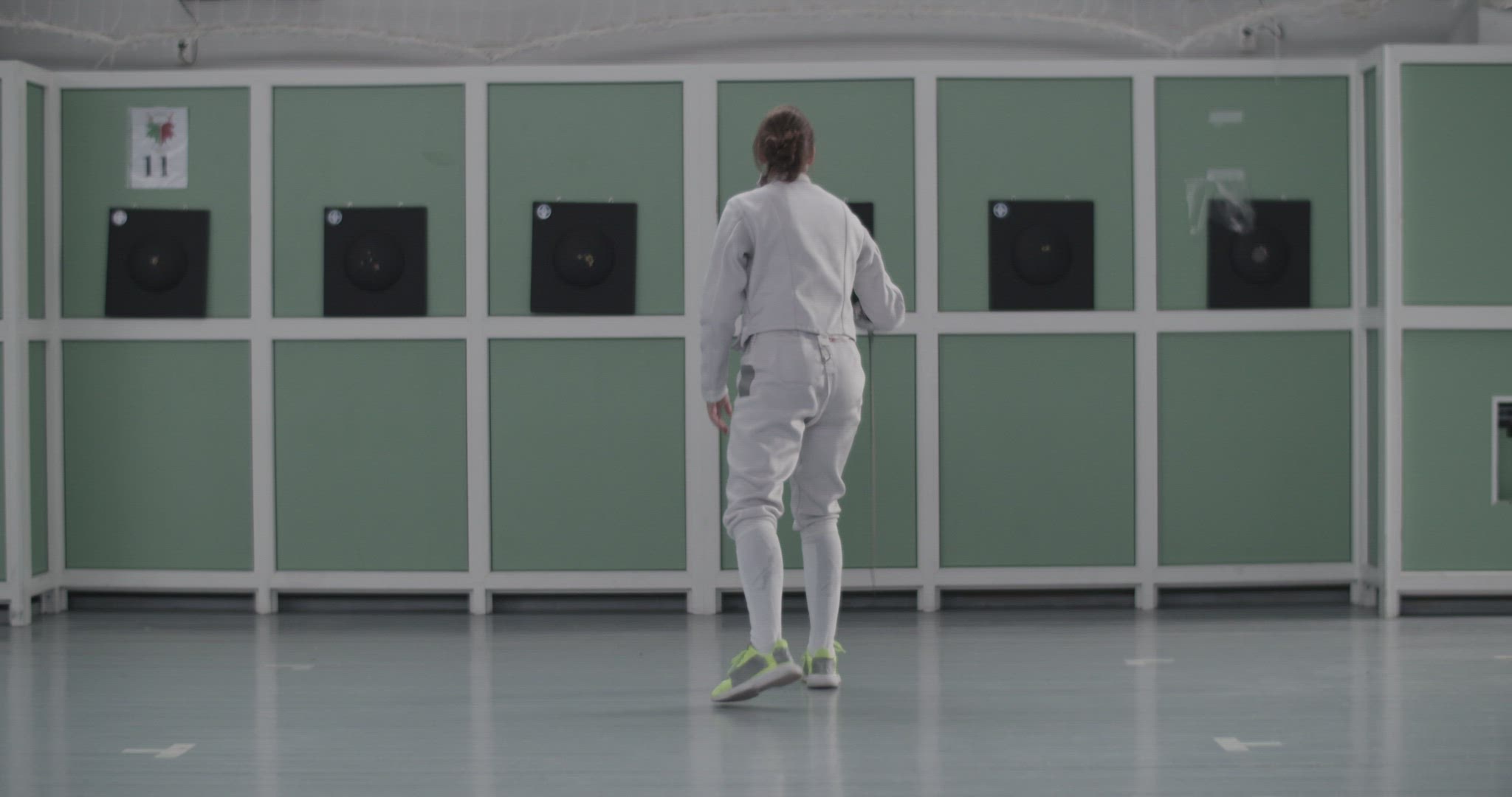 Anonymous fencer practicing in gym alone