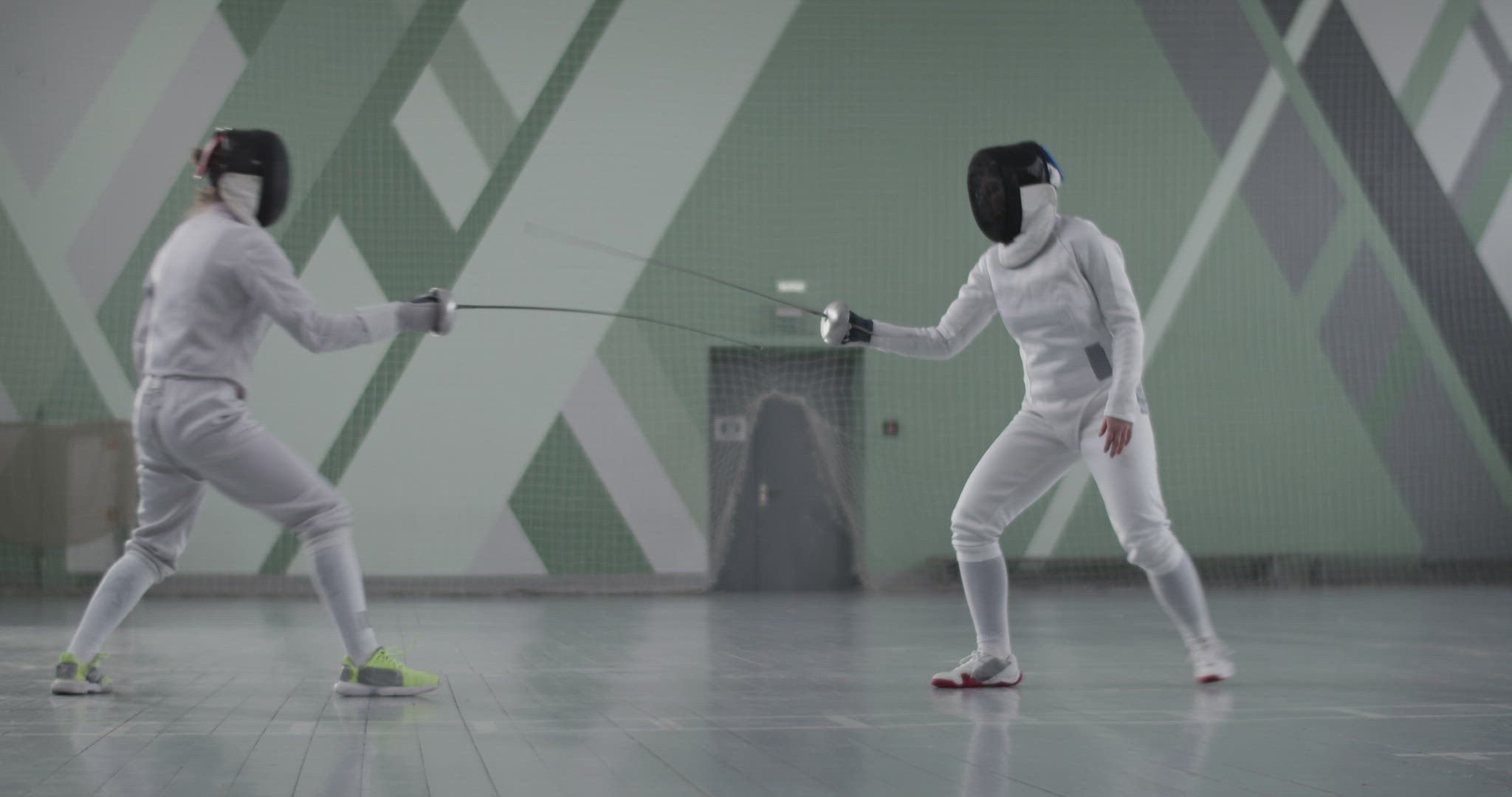 Female fencers practicing in gym together