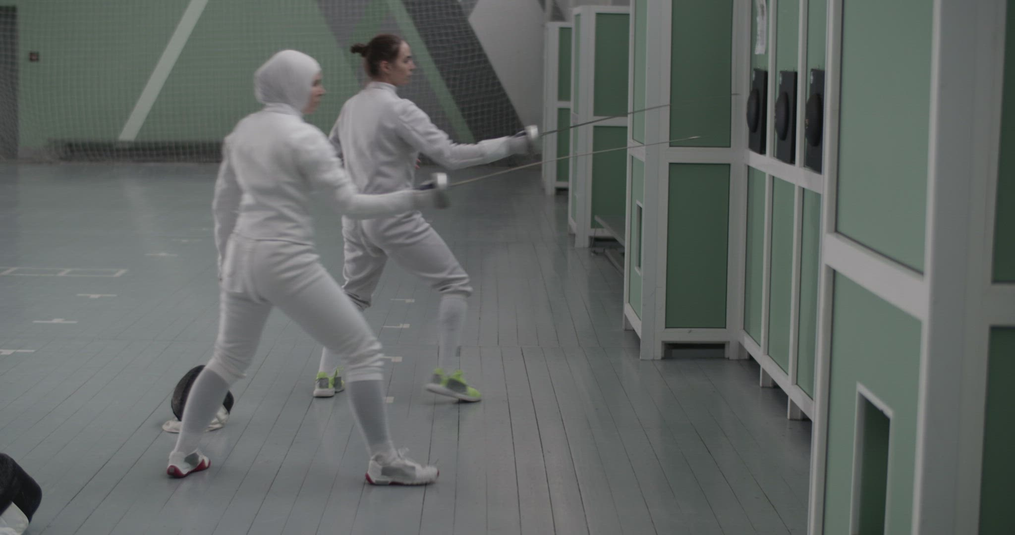Diverse sportswomen attacking targets with foils