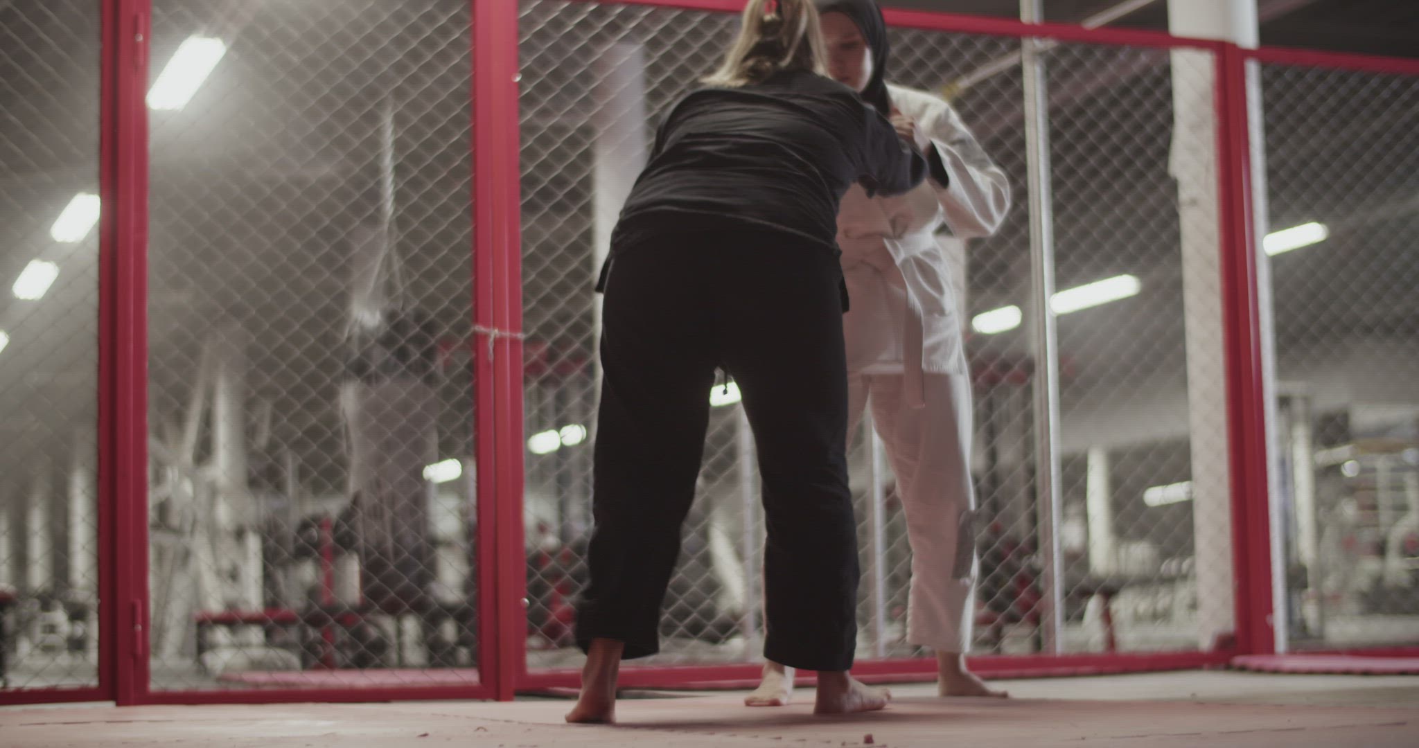 Female fighters during grappling training in gym