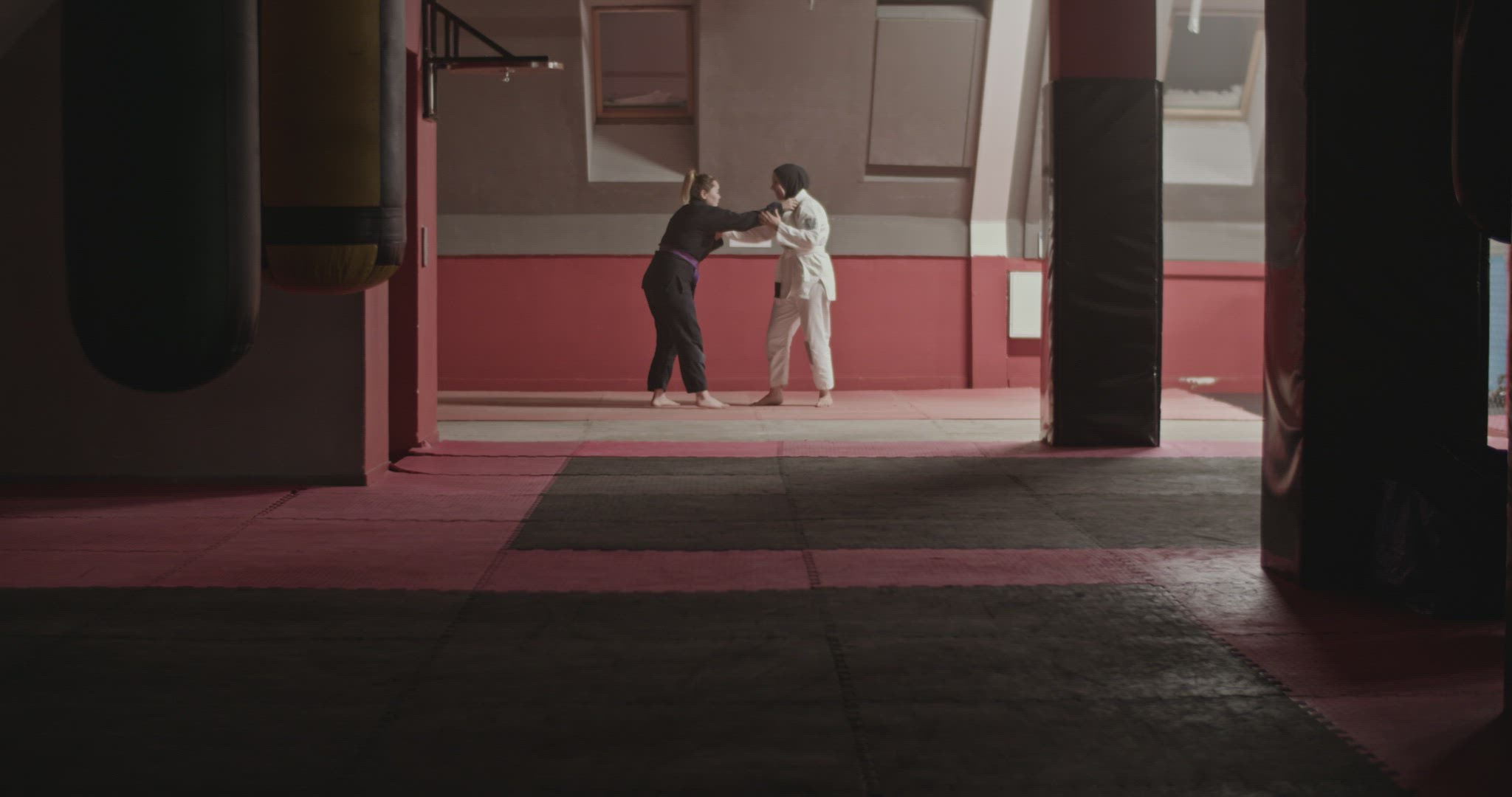 Woman performing takedown and chokehold on Muslim opponent