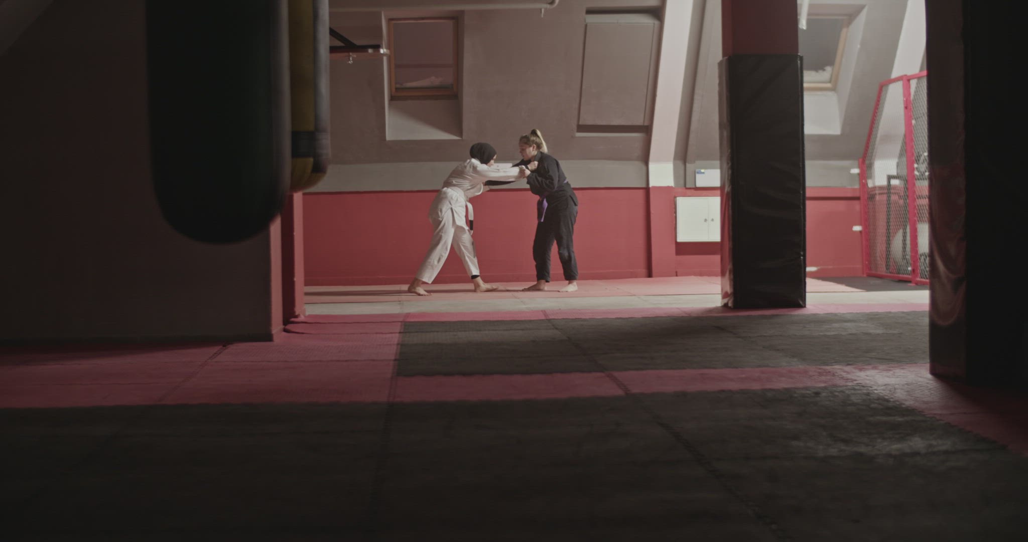 Female fighters during grappling training in gym