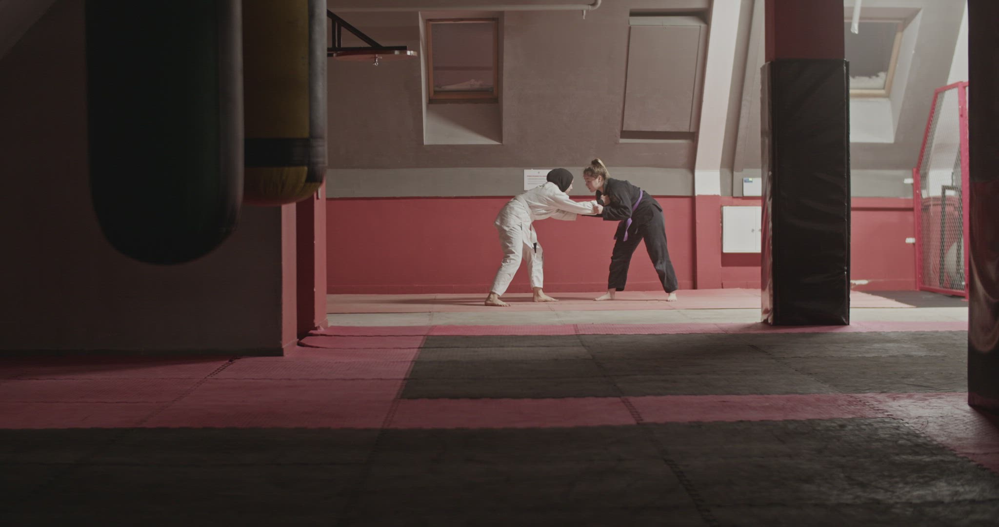 Woman performing takedown and chokehold on Muslim opponent