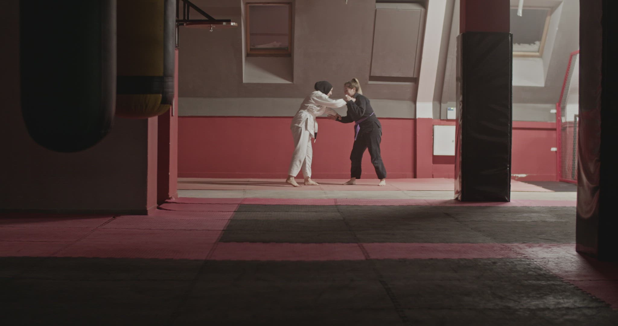 Woman performing takedown and chokehold on Muslim opponent