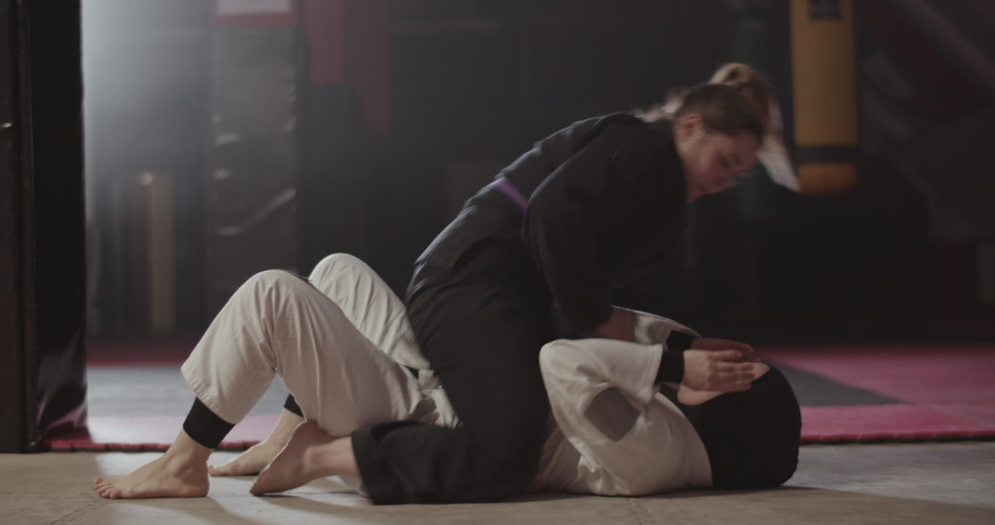Woman performing armlock during fight with Muslim opponent