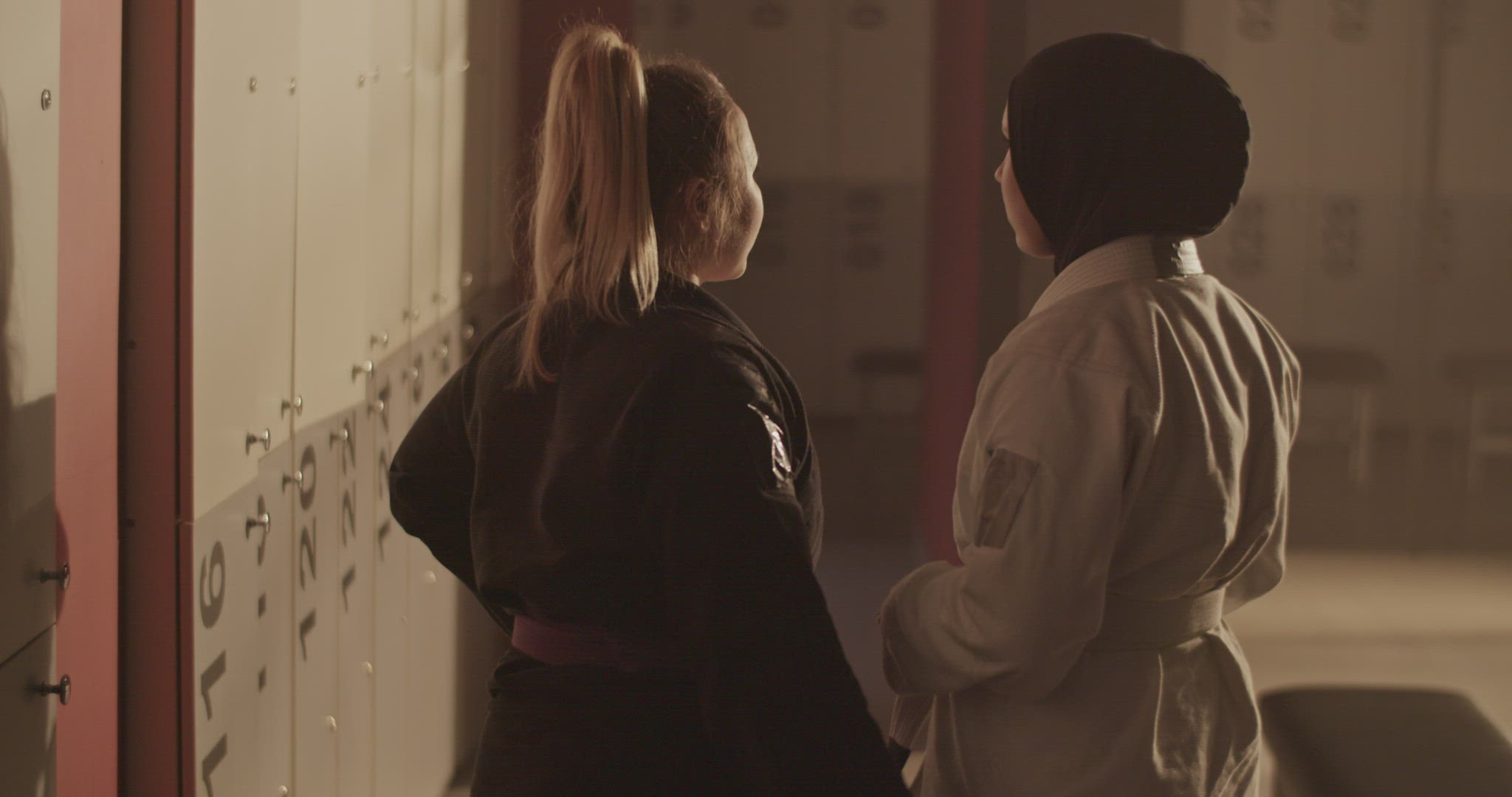 Trainer supporting wrestler near lockers