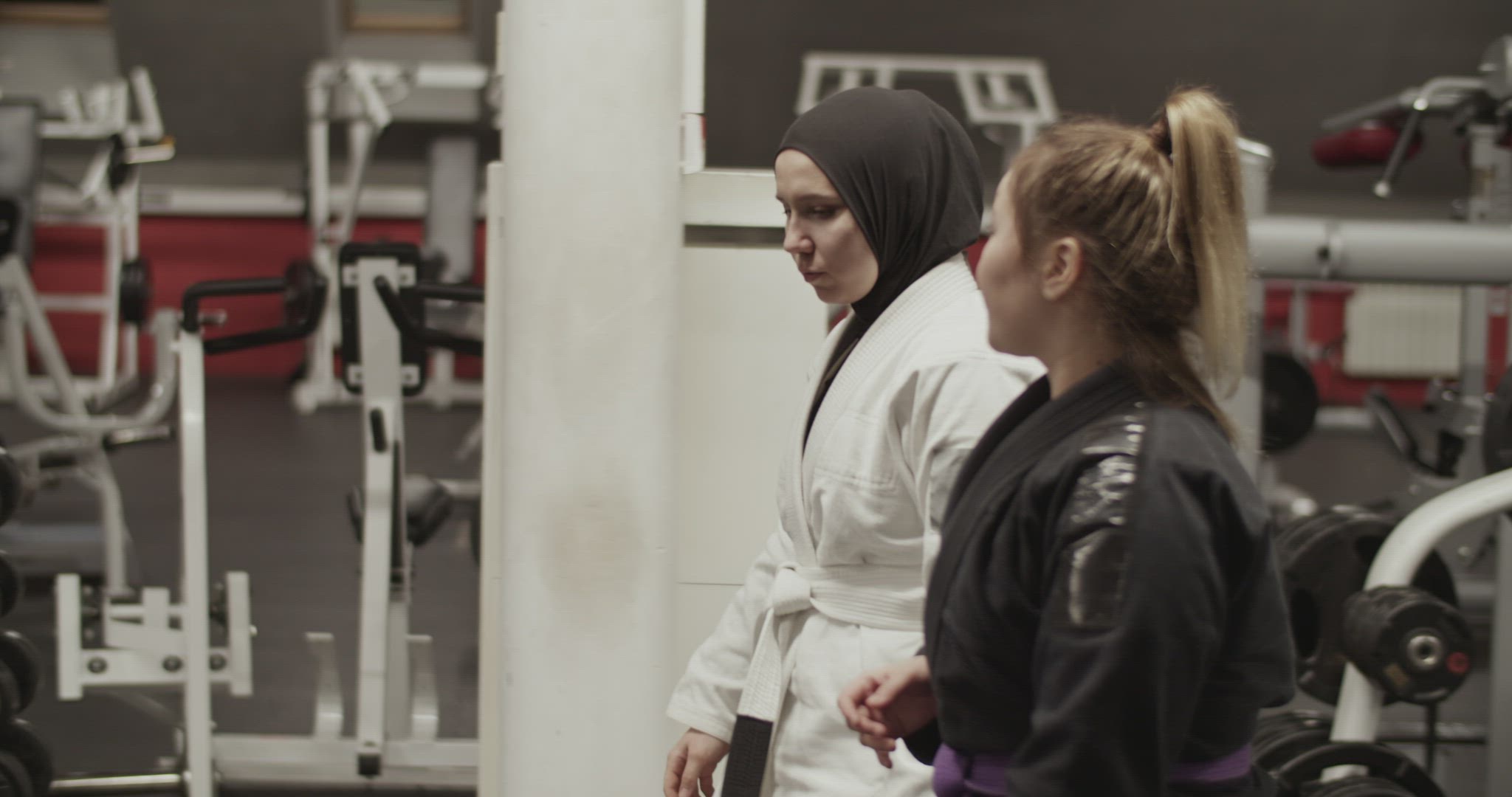 Female wrestlers walking and talking in gym