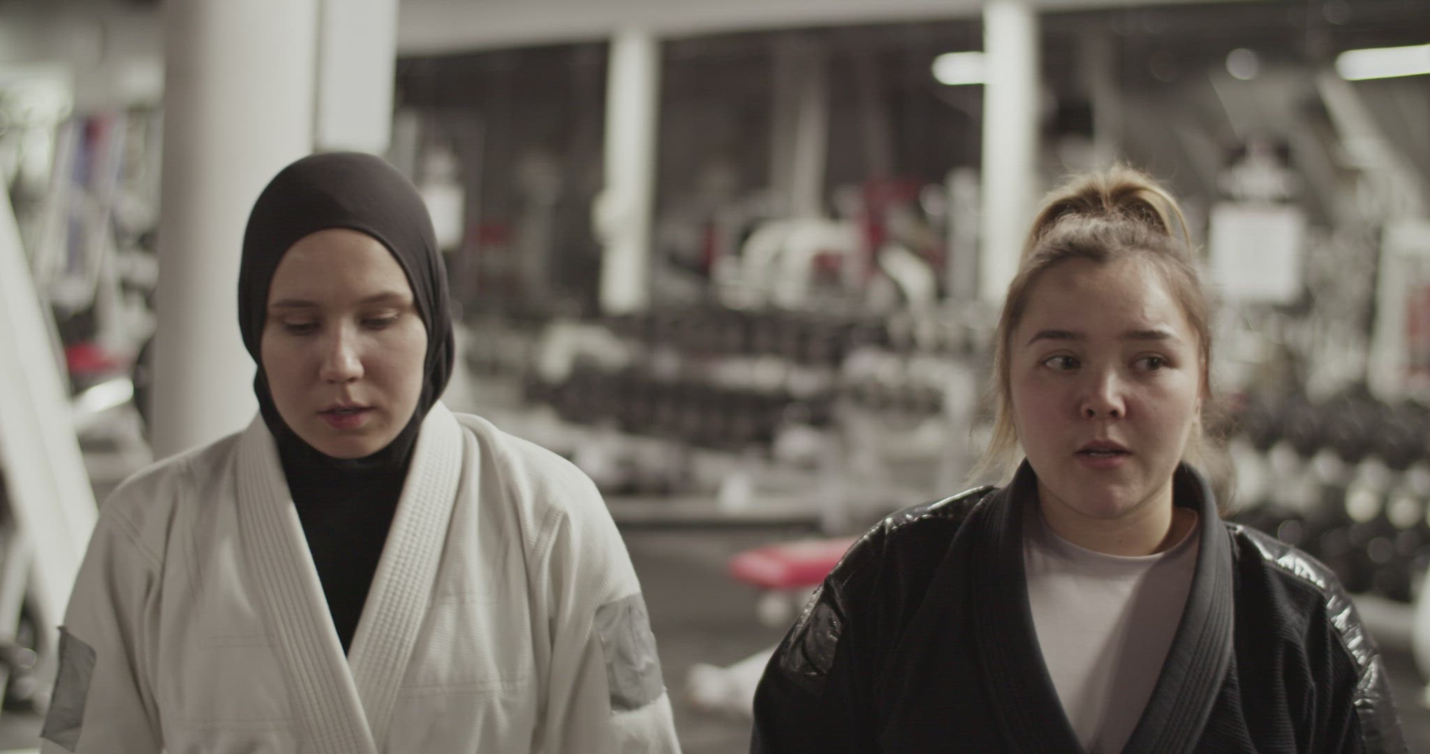 Diverse female fighters chatting before training in gym