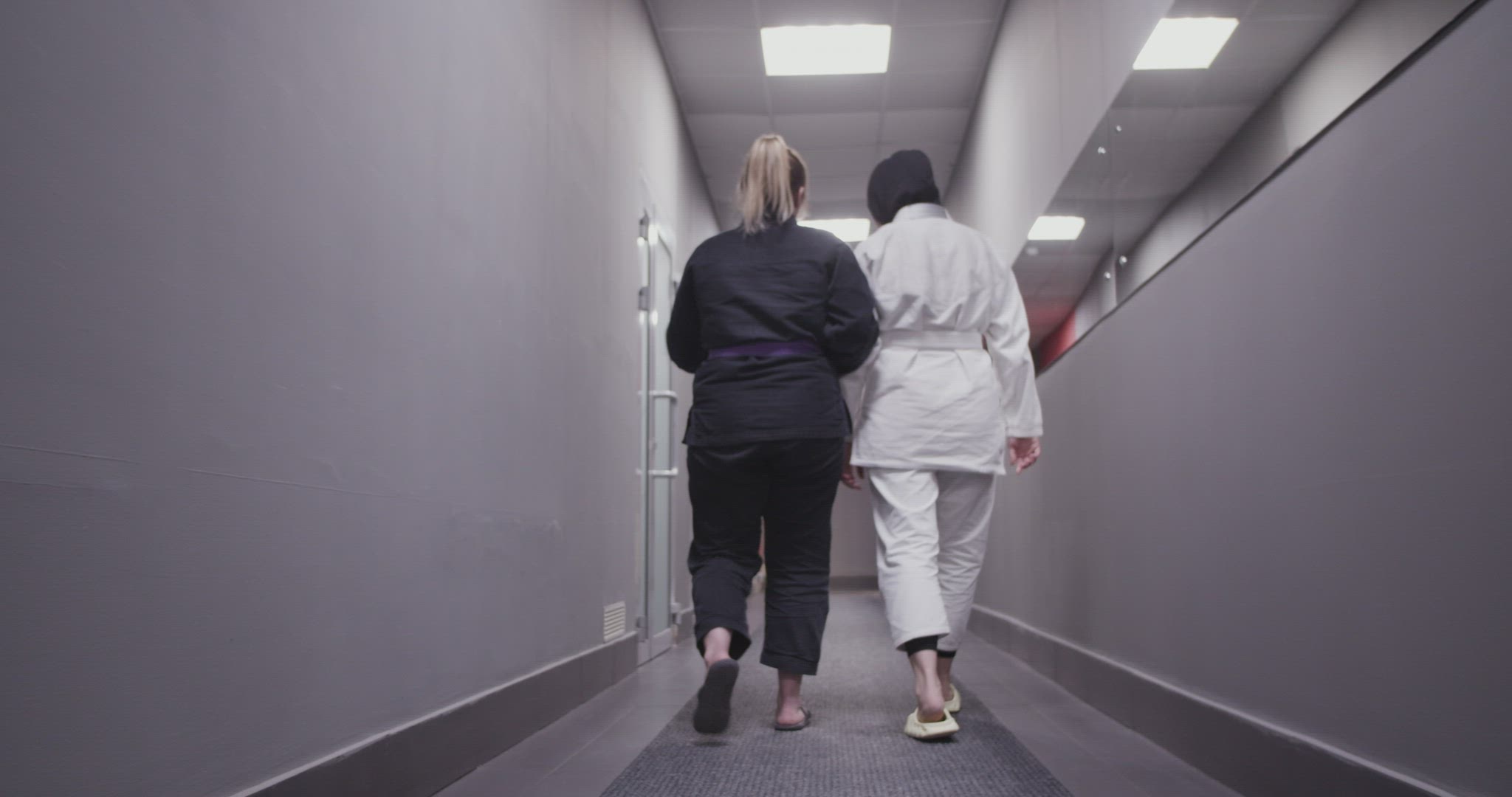 Diverse fighters walking in corridor and discussing training