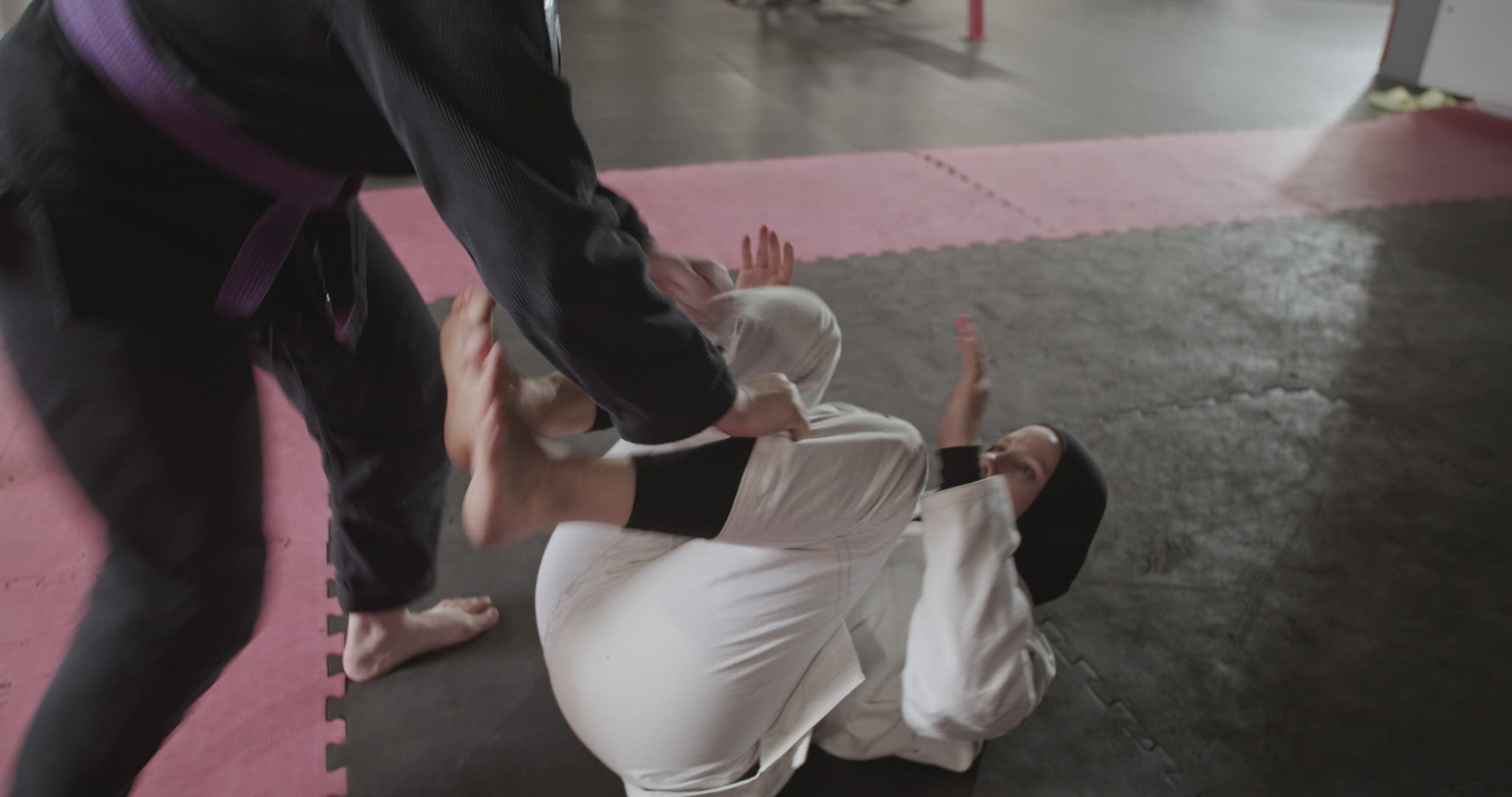 Crop trainer helping Muslim fighter to practice escape technique