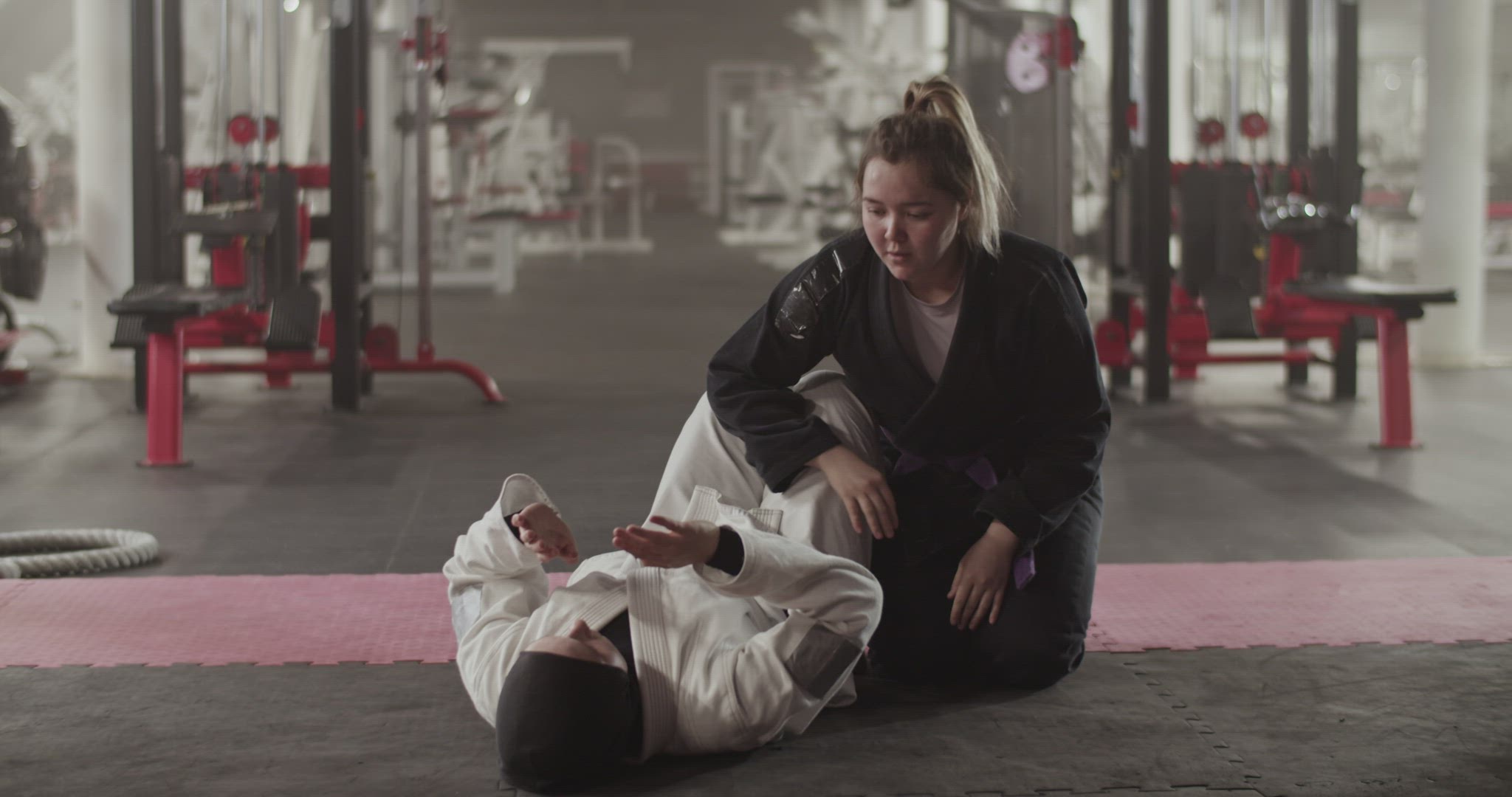 Female fighters doing BJJ drill in gym
