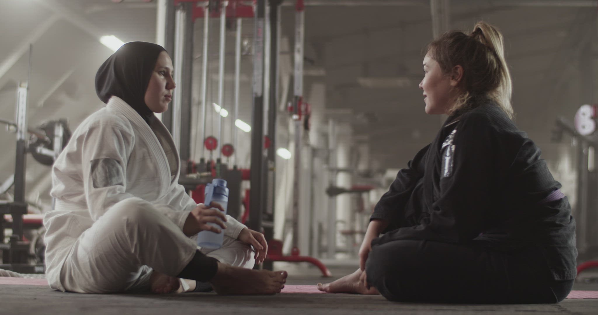 Female trainer speaking with Muslim wrestler