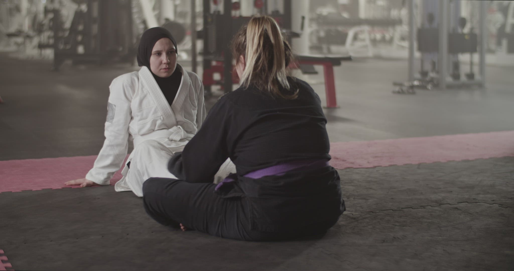 Female coach speaking with Muslim wrestler