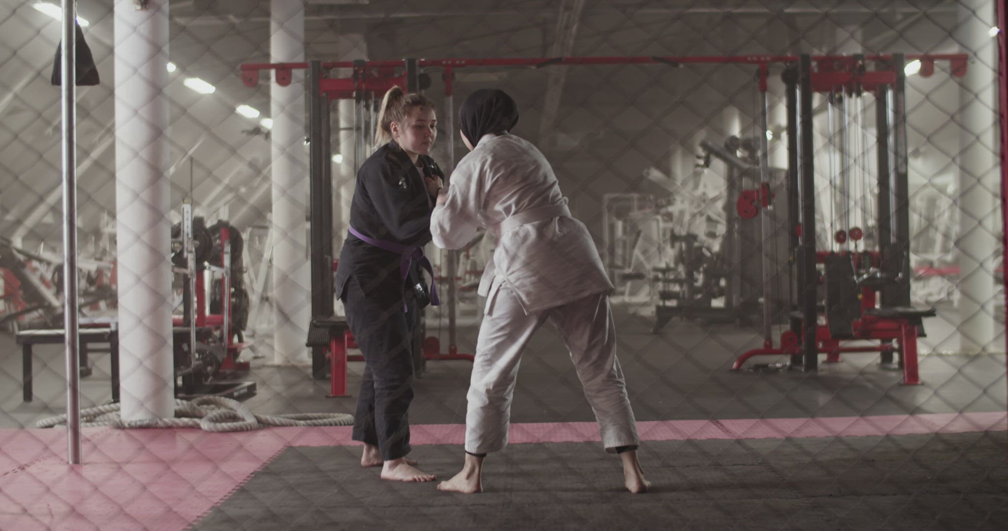 Female wrestlers sparring behind net