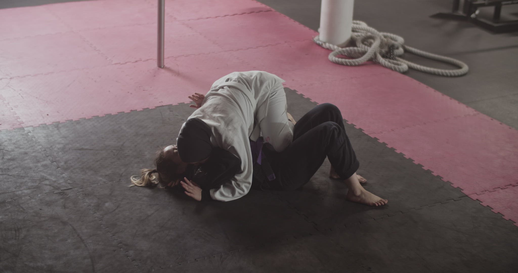 Women practicing grappling holds on floor