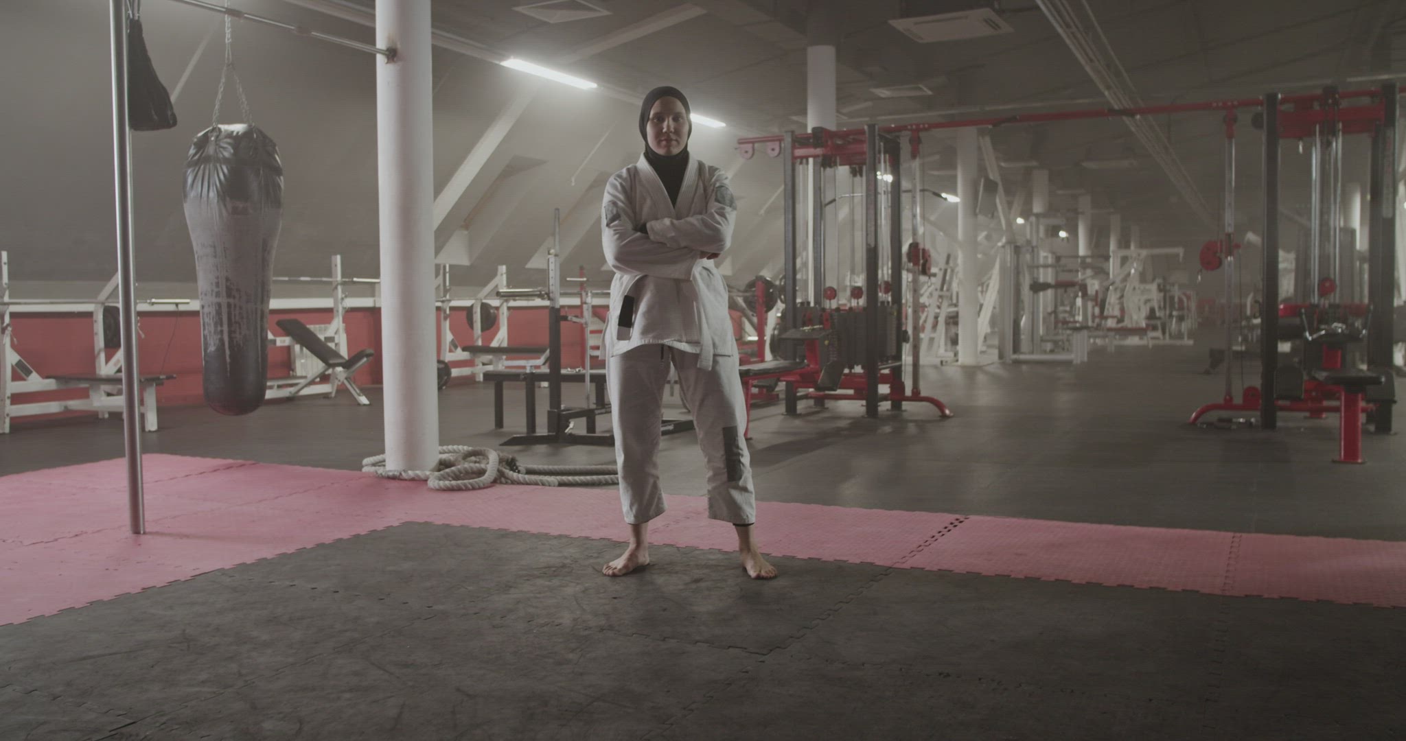 Barefoot BJJ fighter with crossed arms