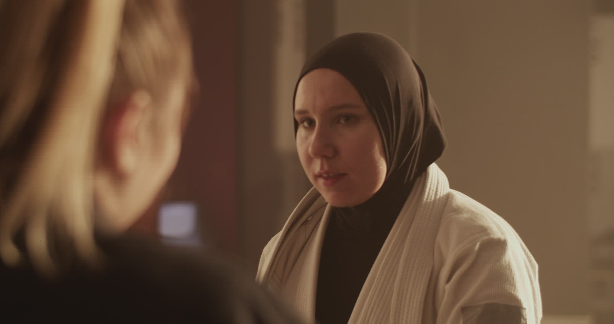 Muslim fighter drinking water and speaking with trainer
