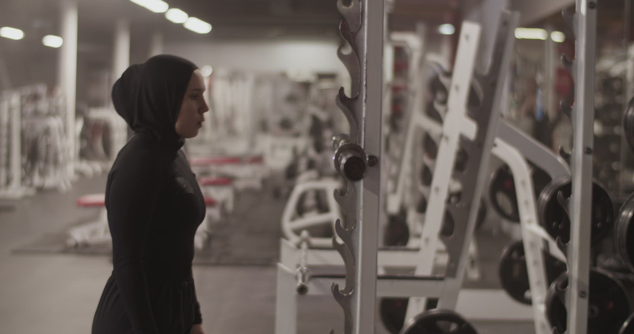 Muslim sportswoman putting barbell on shoulders