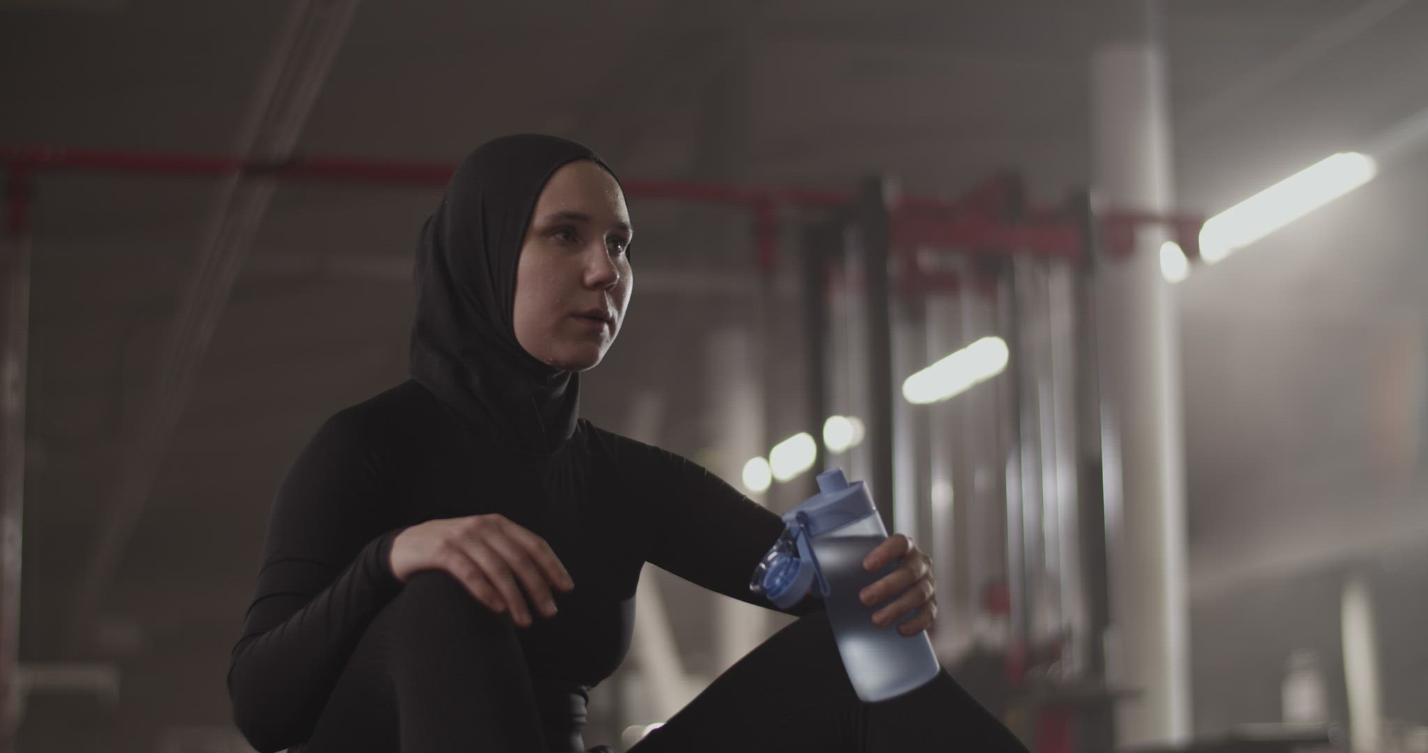 Muslim sportswoman taking break in gym