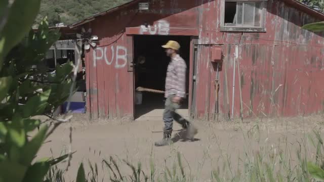 Man at organic farm working near red barn