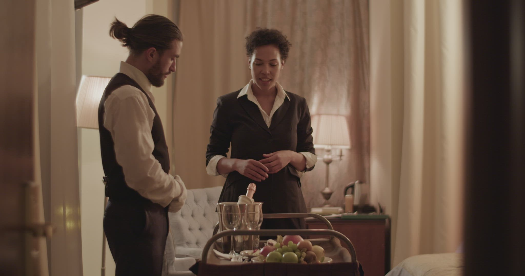 Positive waiter and guest communicating during room service at hotel