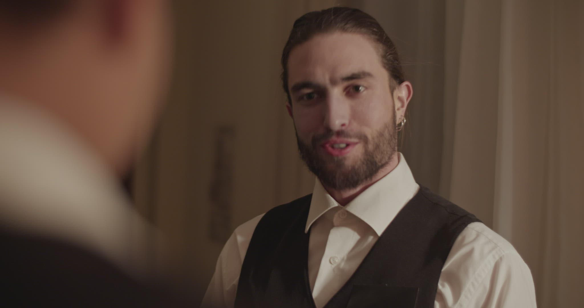 Friendly professional waiter speaking with unrecognizable guest during room service