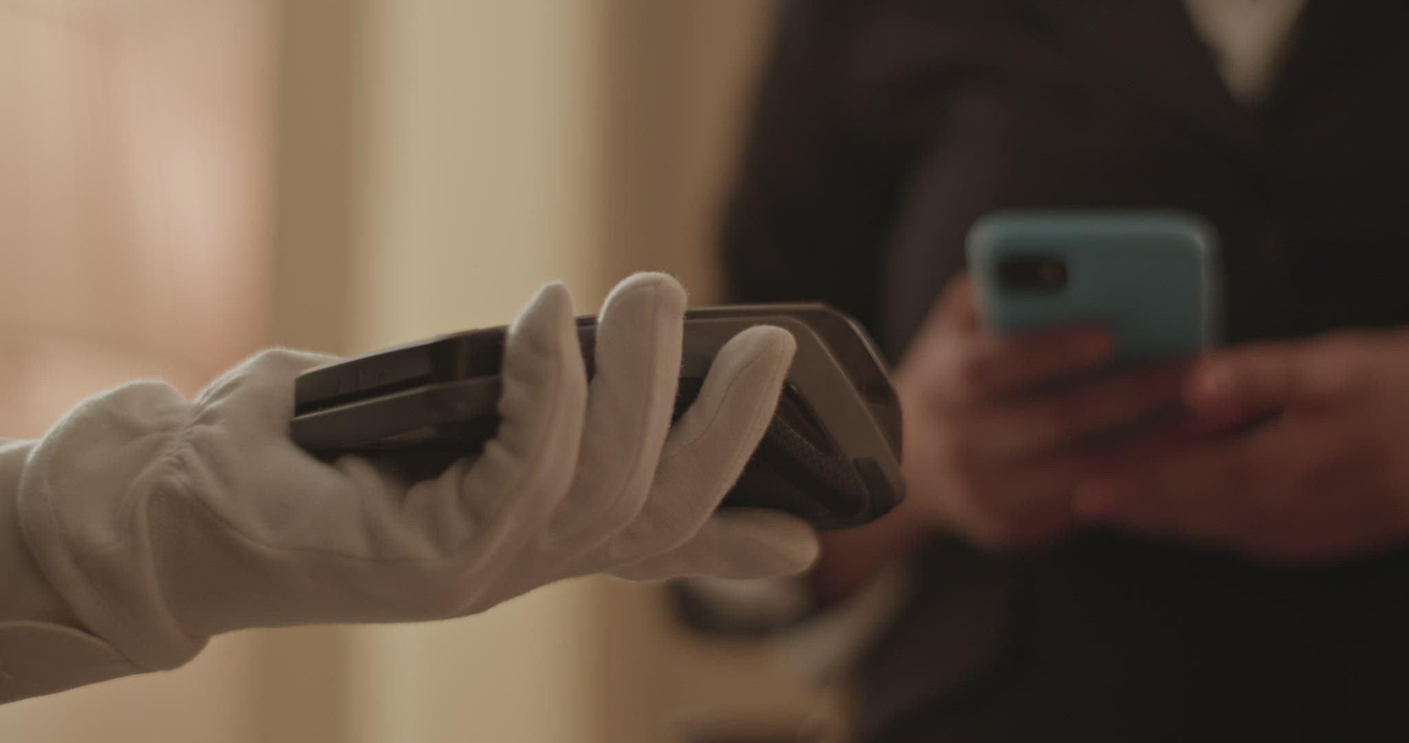 Crop woman using smartphone while paying for room service contactless