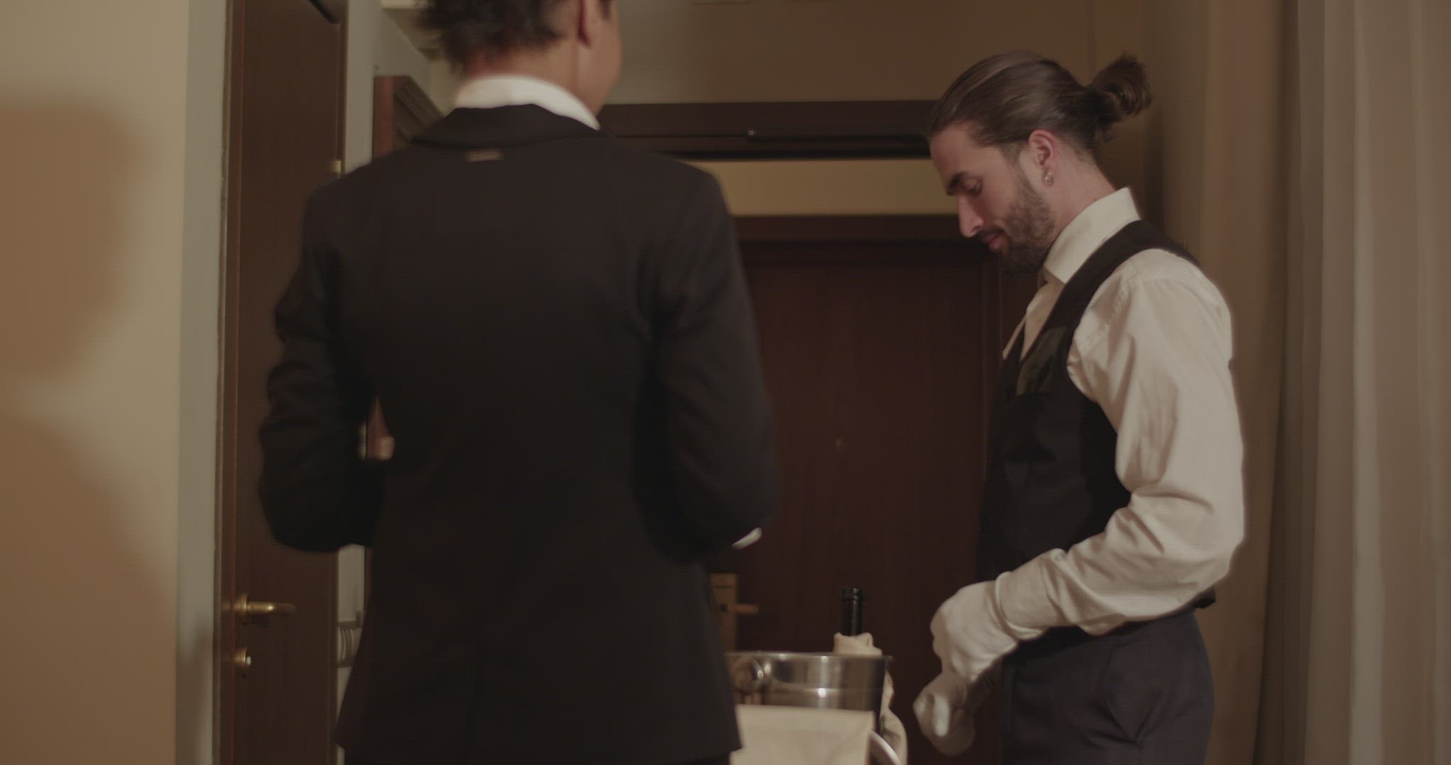 Ethnic woman making NFC payment for room service to waiter