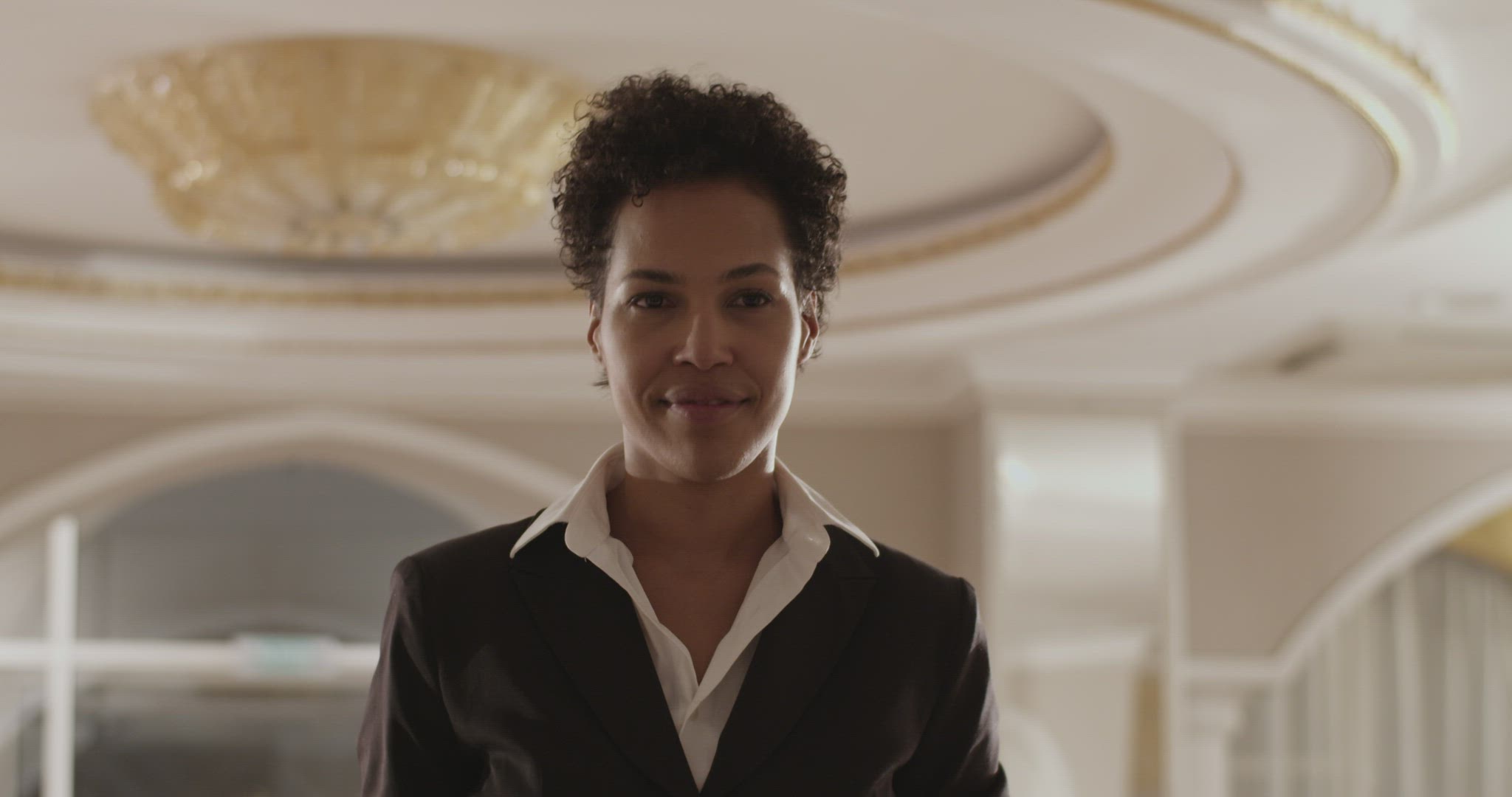 Happy elegant black businesswoman smiling while arriving at hotel