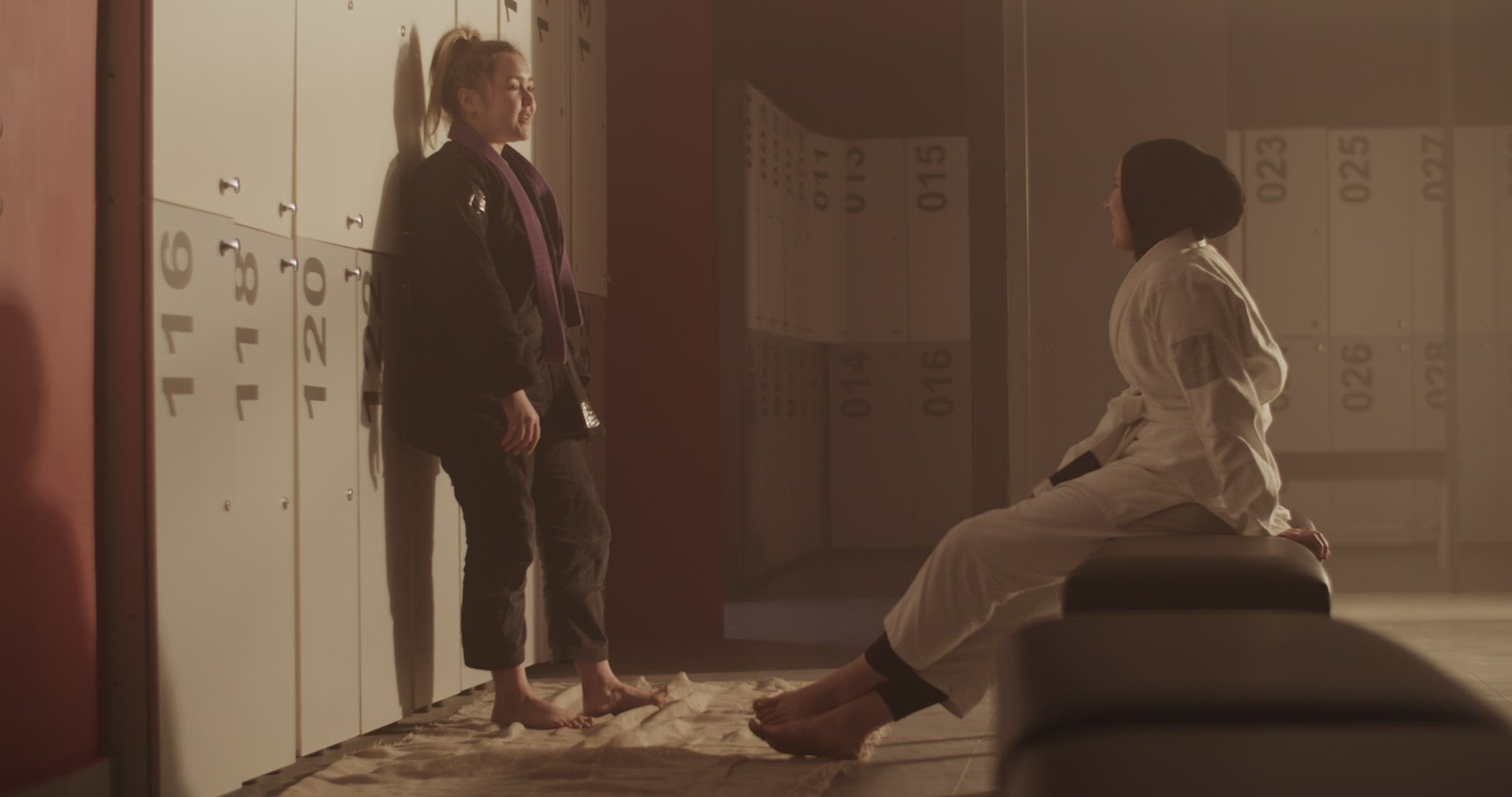 Multiracial female fighters chatting near lockers