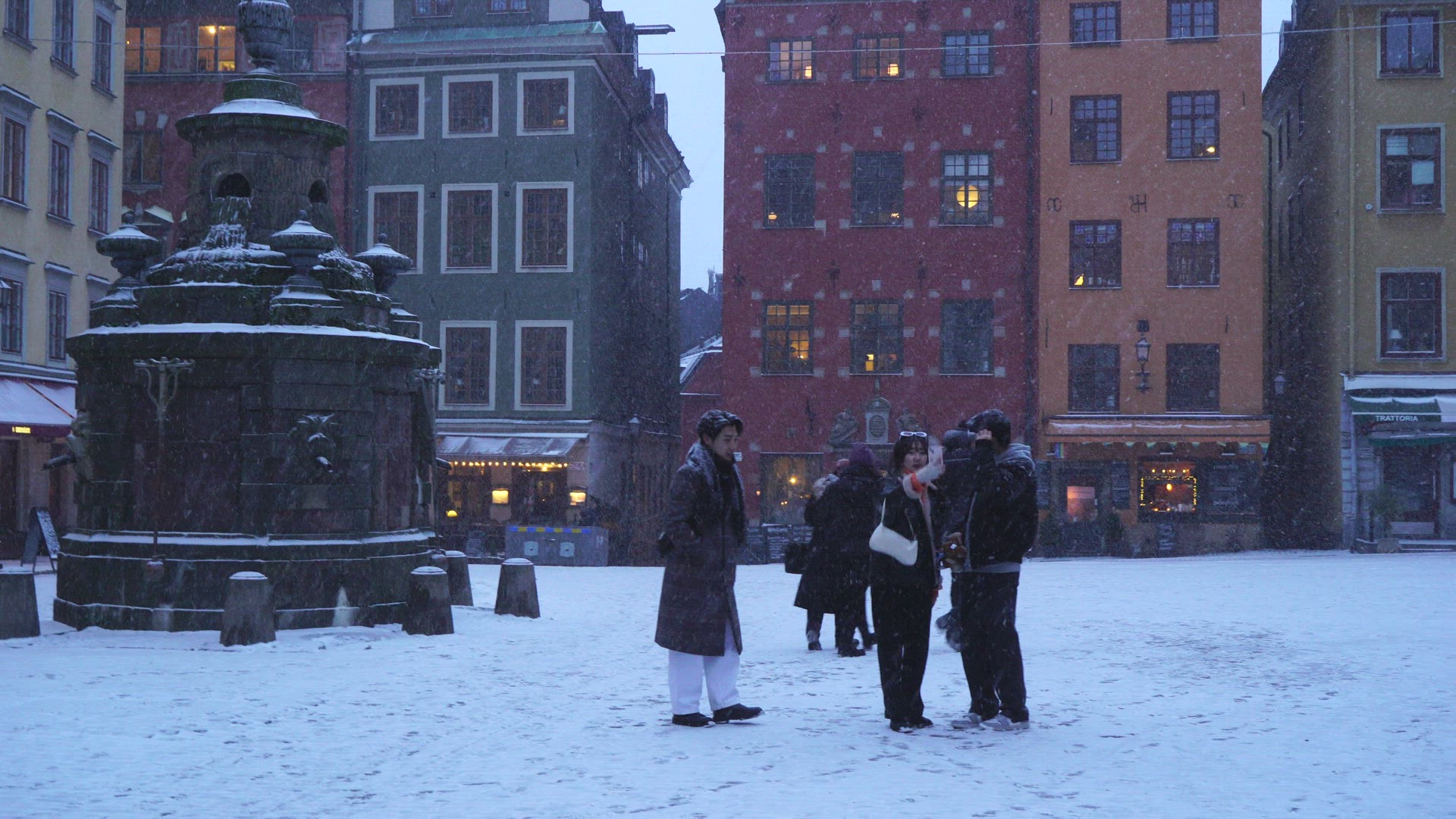 snowy weather in old town in Stockholm - group of tourists taking selfies on Stortorget