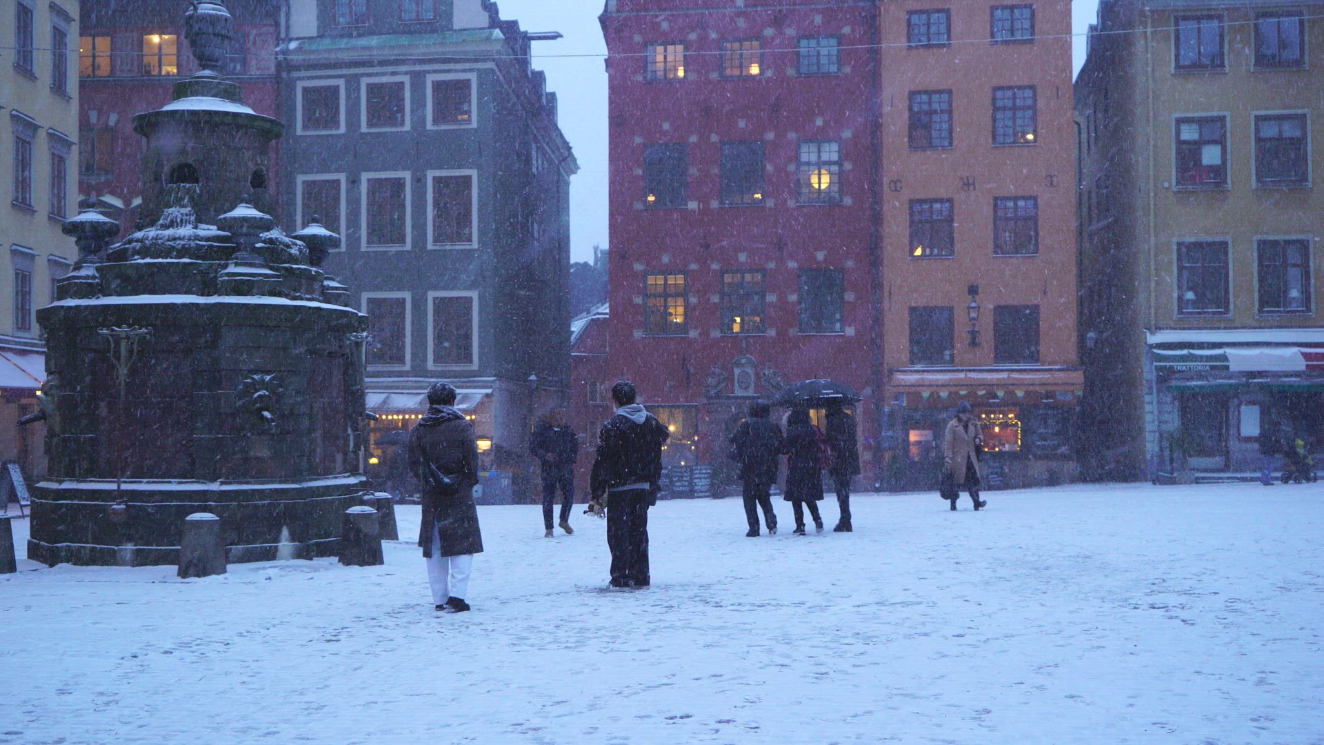 tourists on Stortorget in Old Town Stockholm -snow falling heavily - taking pictures