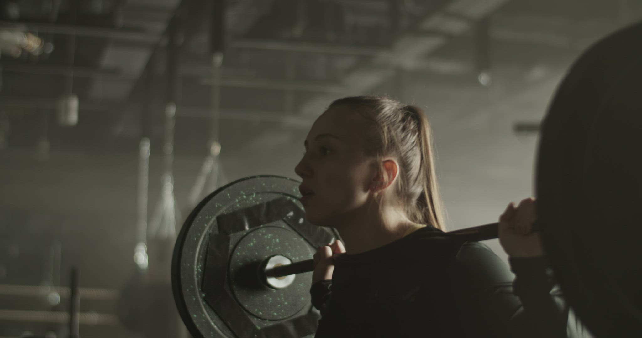Determined woman with barbell preparing for exercise in gym