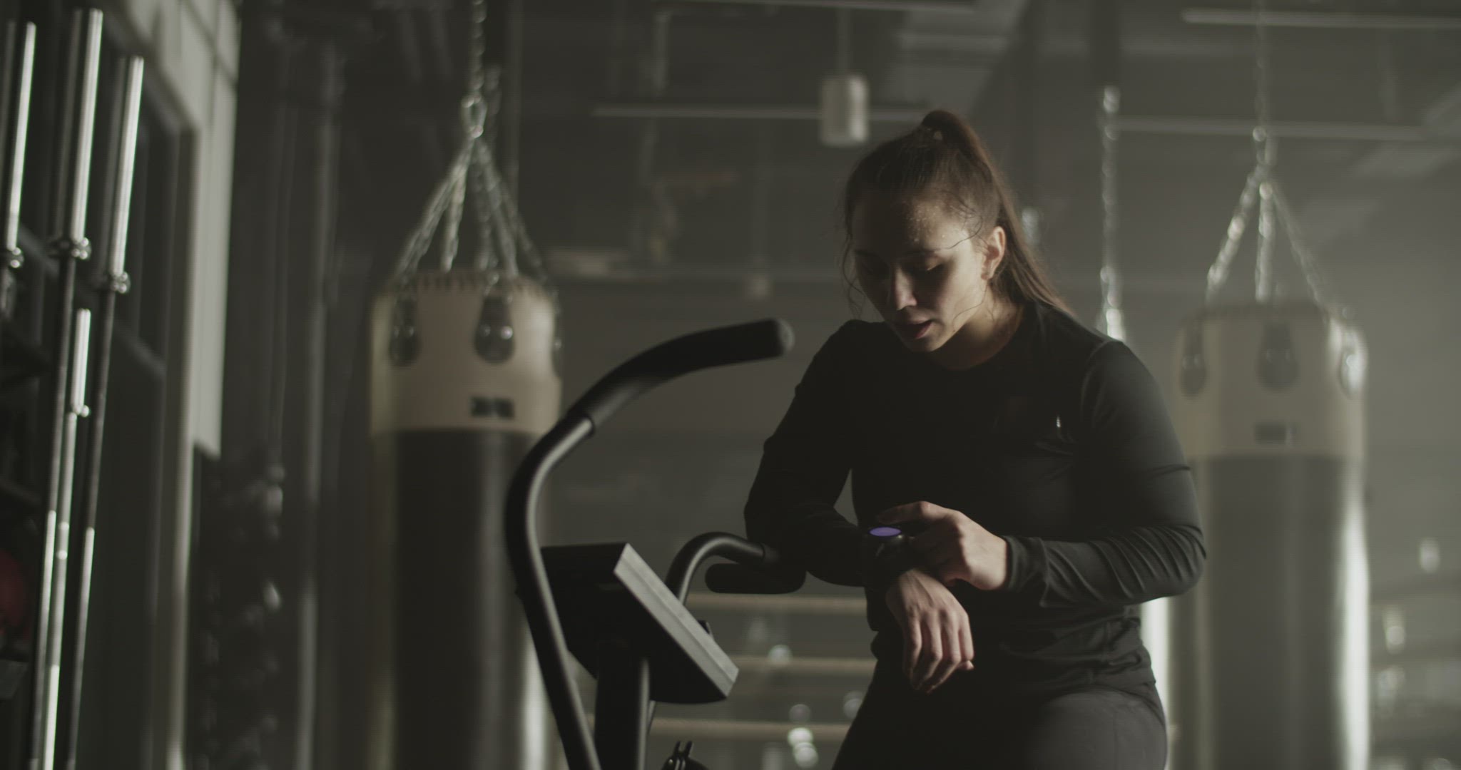 Exhausted sportswoman checking pulse on fitness tracker after workout