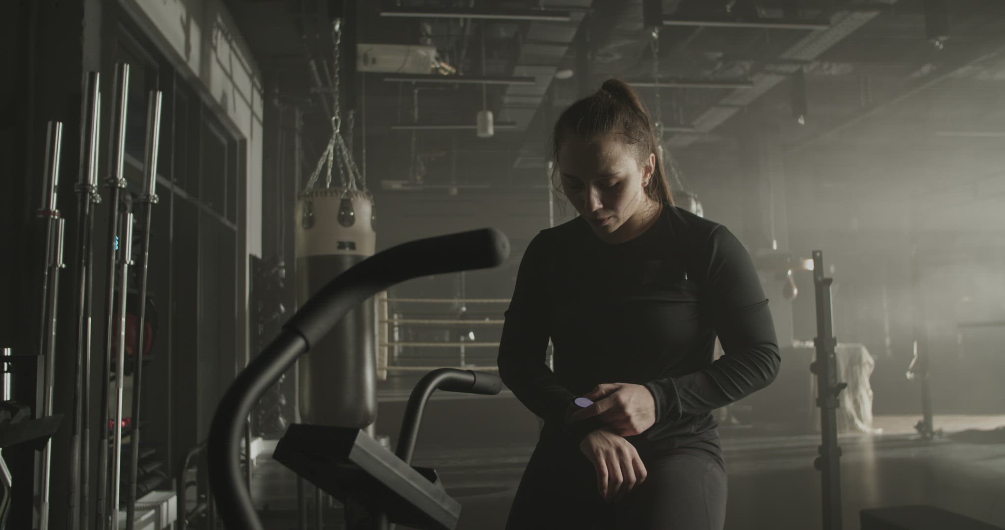 Exhausted sportswoman checking pulse on fitness tracker after workout