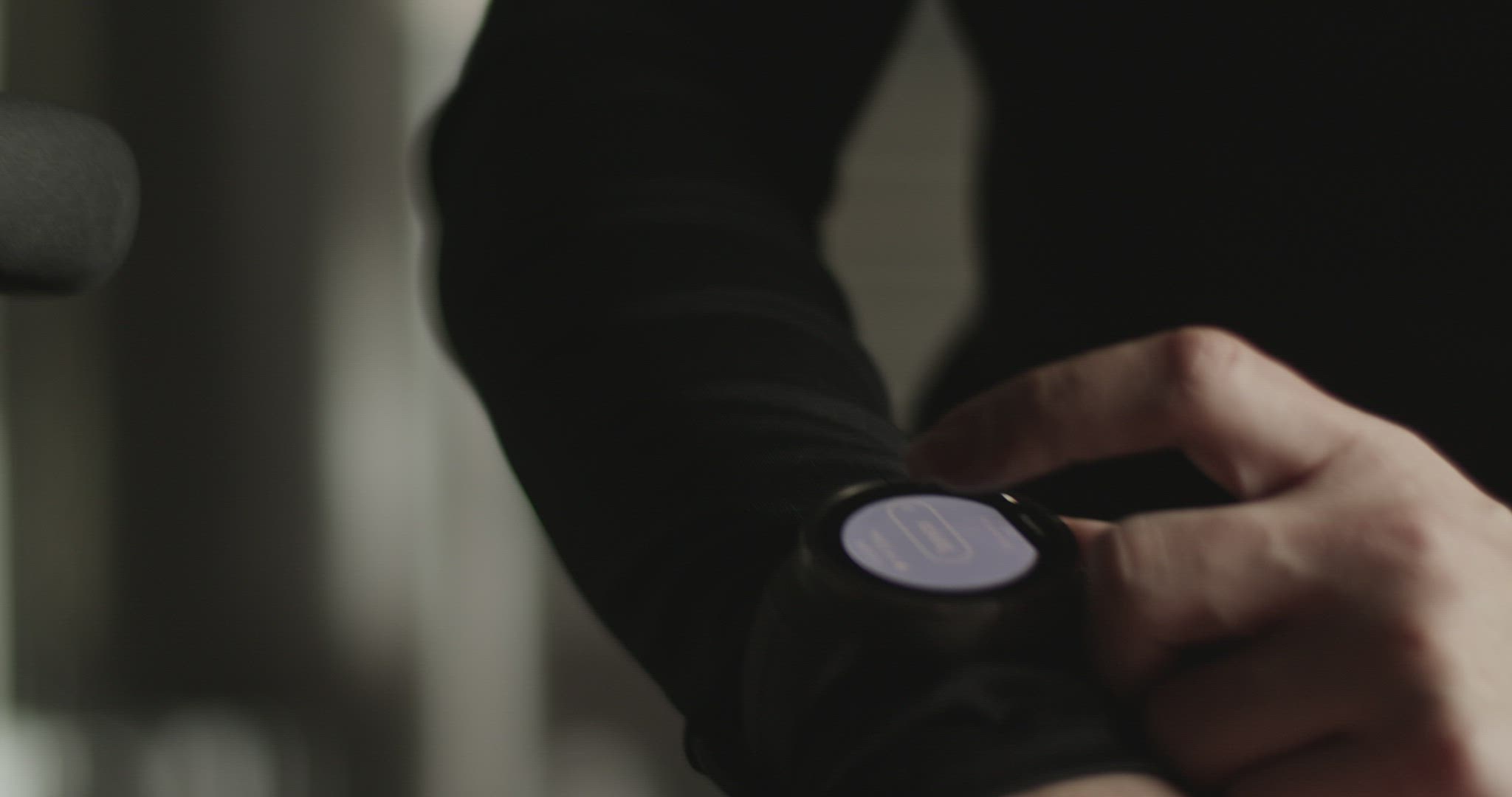 Tired sportswoman using smart watch during workout in gym