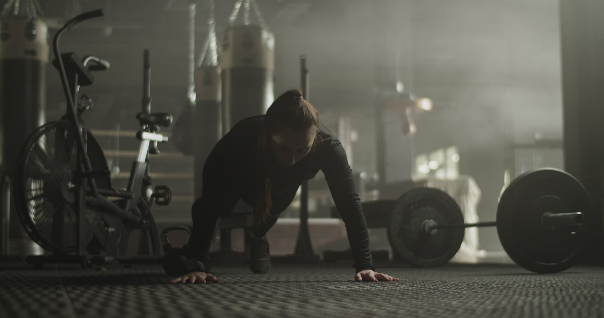 Strong young female athlete doing push ups in gym