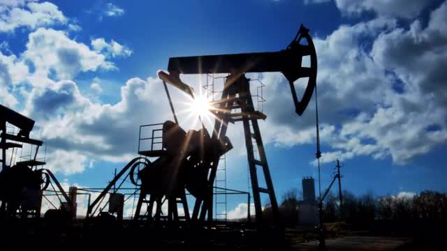 working oil pumps silhouette against timelapse clouds