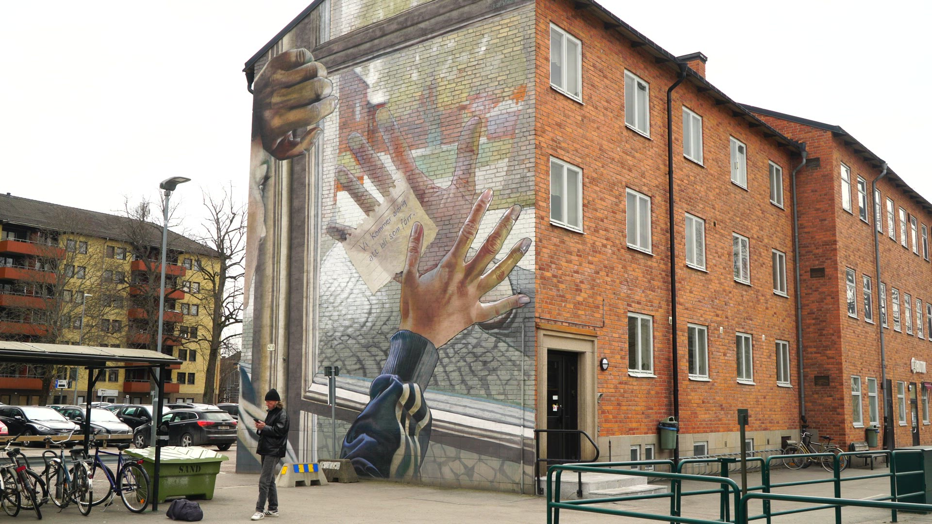 wall painting on house in karlstad - mural painting - man with mobile phone - smoking cigarette