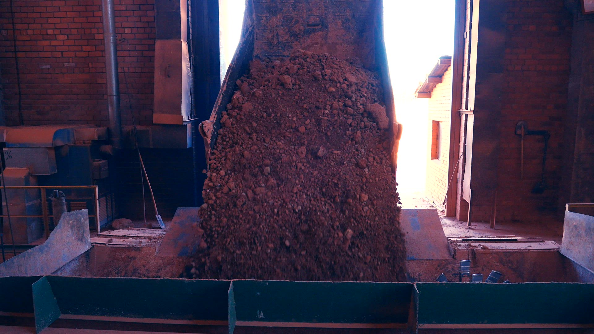 Dump Truck dumps load of clay stones.