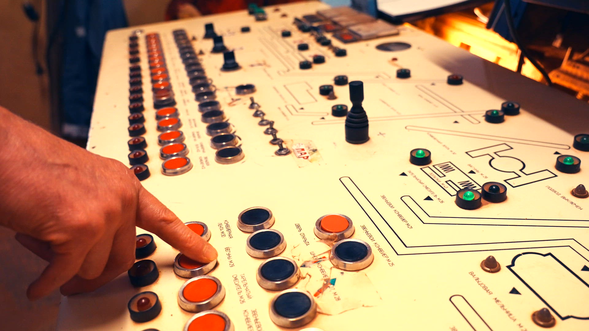 Worker pushing buttons on factory console