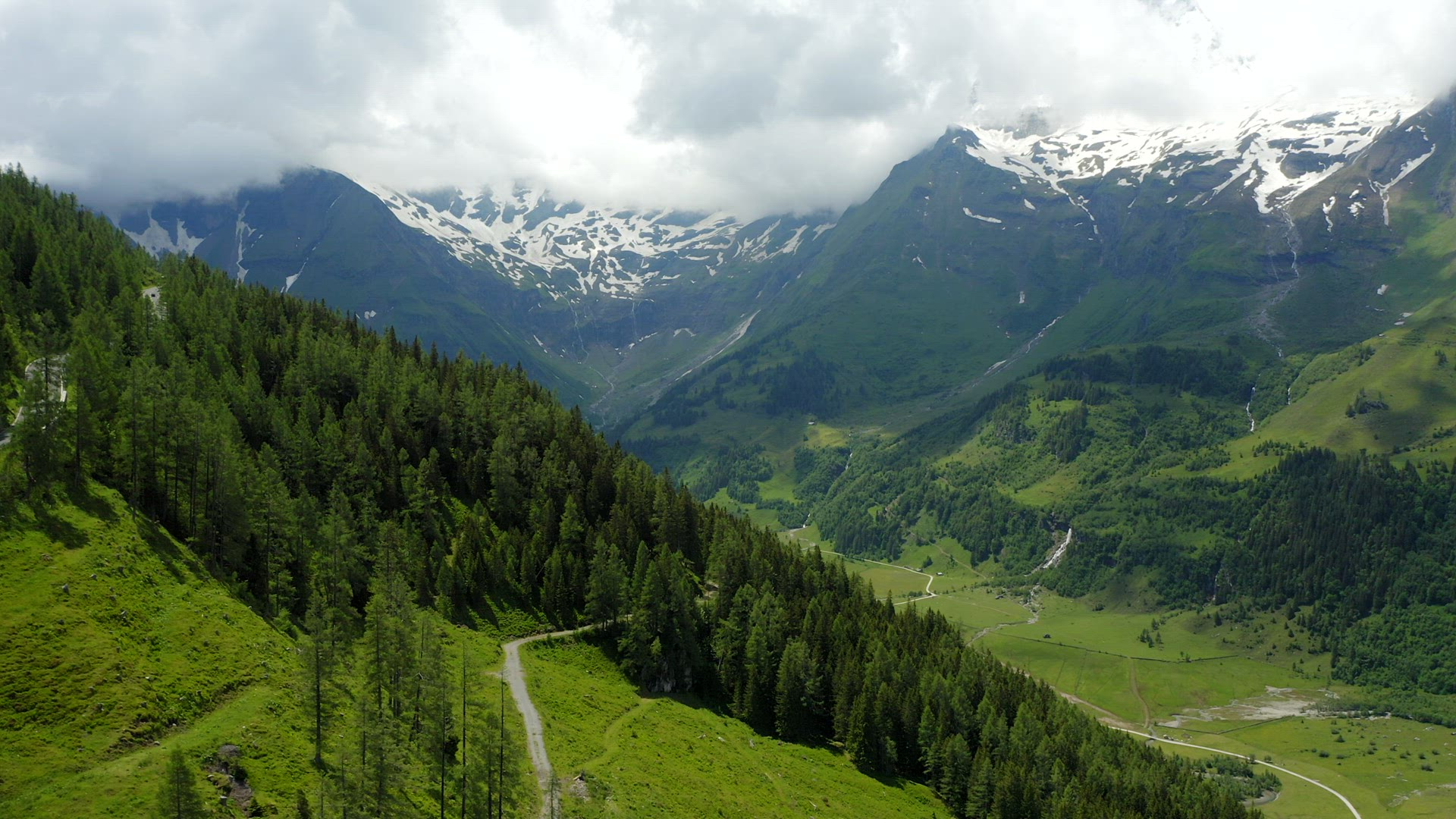 Beautiful scenic green valley surrounded by Alps snowy mountains range on summer day landscape Austr