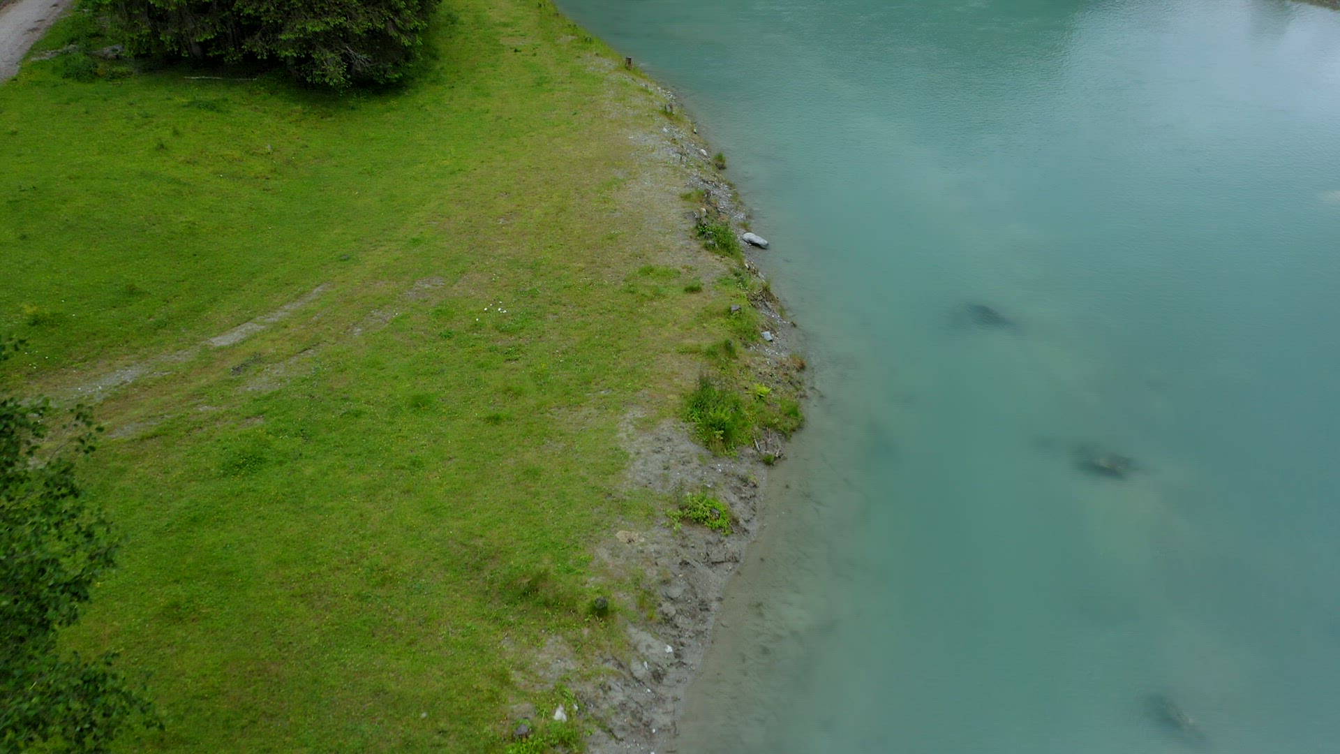 Aerial view of blue water river and green bank and reveal beautiful waterfall and forest in backgrou
