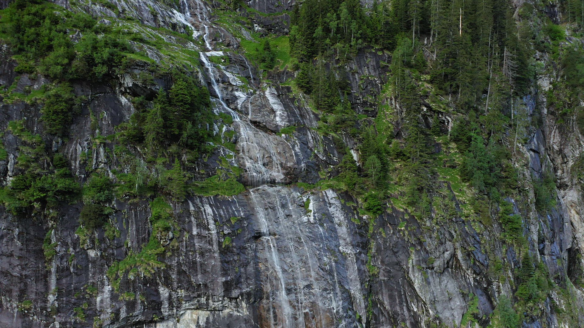 Austria, Tyrol. Aerial up movement in front of mountain waterfall. Stillup Lake,