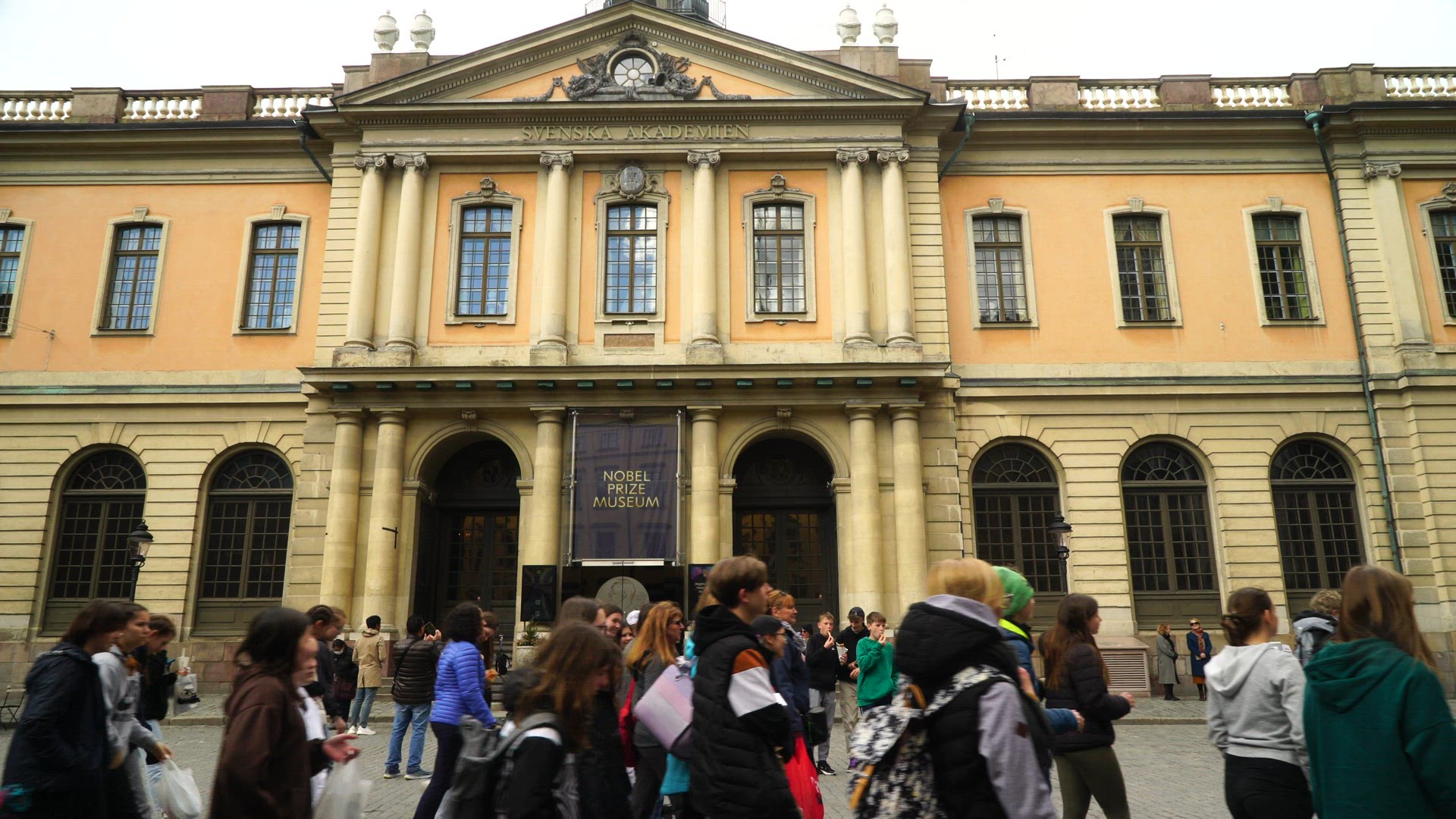 crowd of young people walking outside Nobel Prize Museum in Old Town in Stockholm - tourists