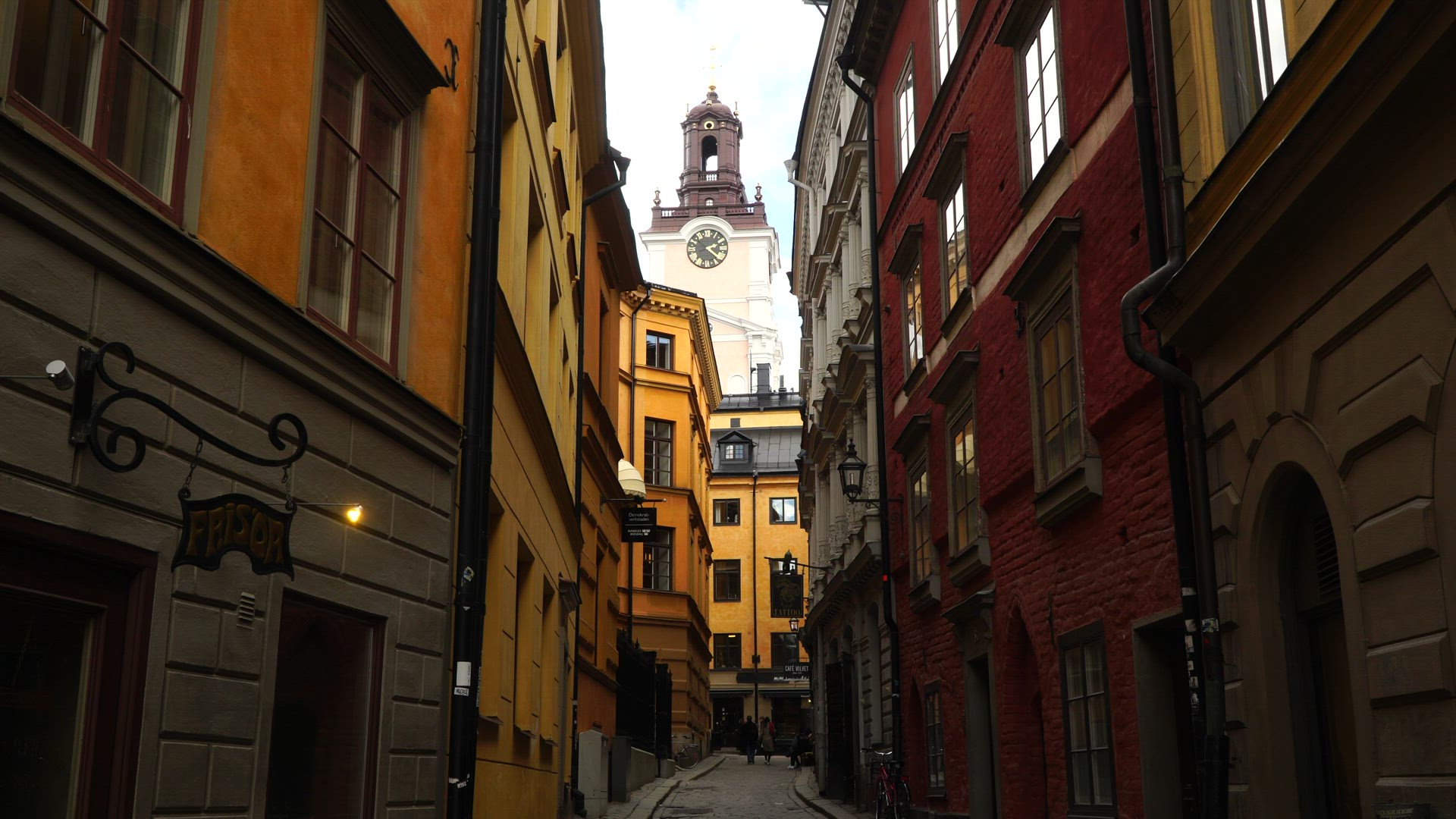 narrow street in old town in stockholm - alley - couple walking hand in hand - holding hands