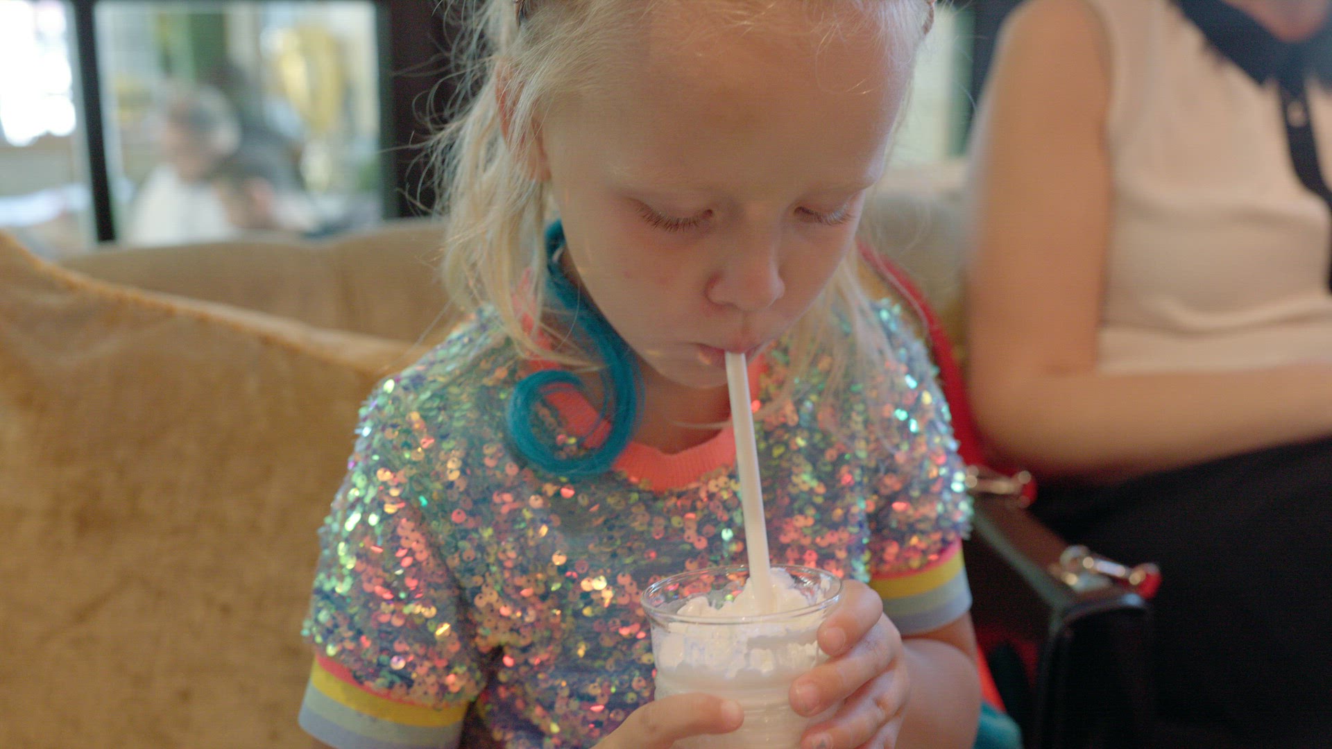 Kid drinking delicious milkshake in cafe