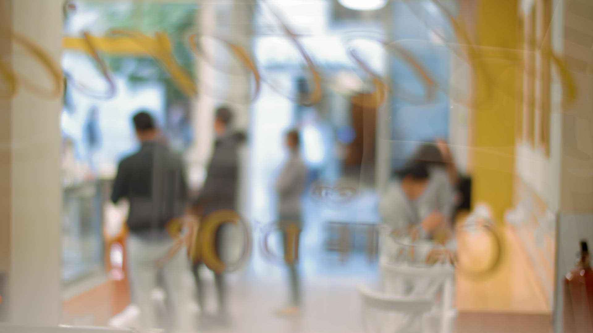 Cafeteria guests waiting in queue, blurry view through the glass